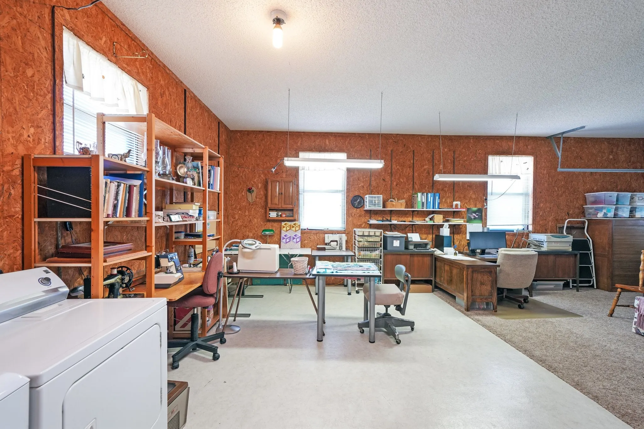 Home office with washer / clothes dryer, a textured ceiling, and a healthy amount of sunlight