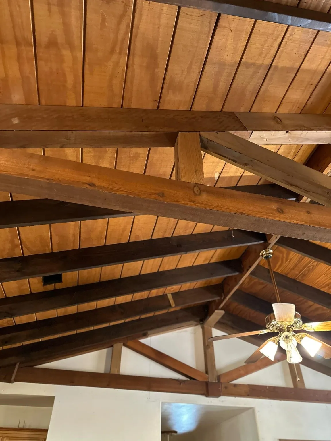 Room details with ceiling fan, beamed ceiling, and wooden ceiling