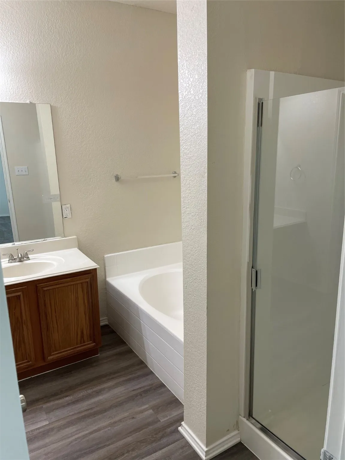 Bathroom with vanity, plus walk in shower, and hardwood / wood-style flooring