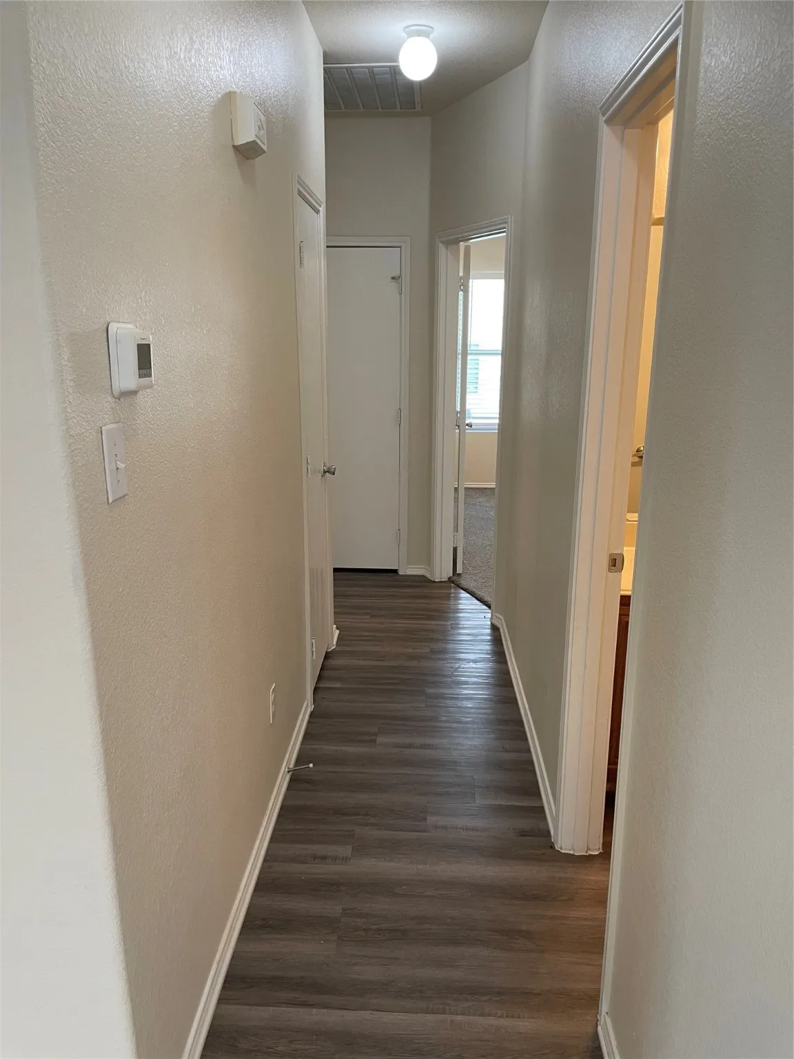 Corridor featuring dark wood-type flooring