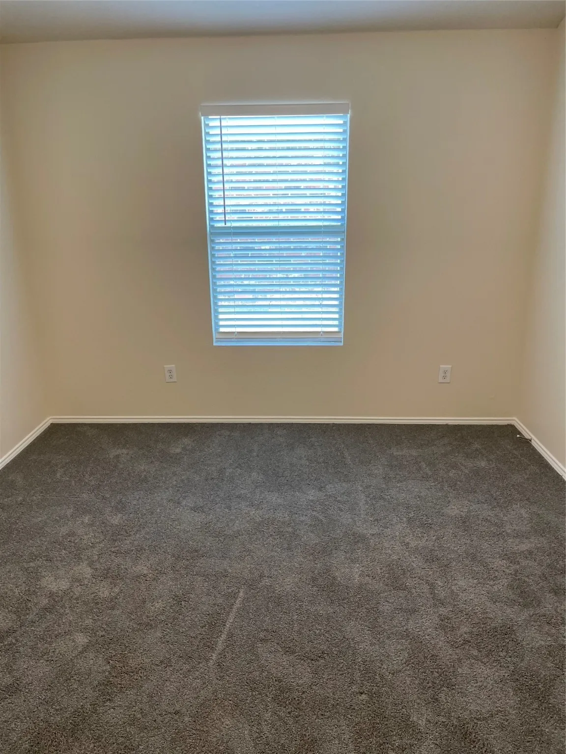 Spare room featuring dark carpet