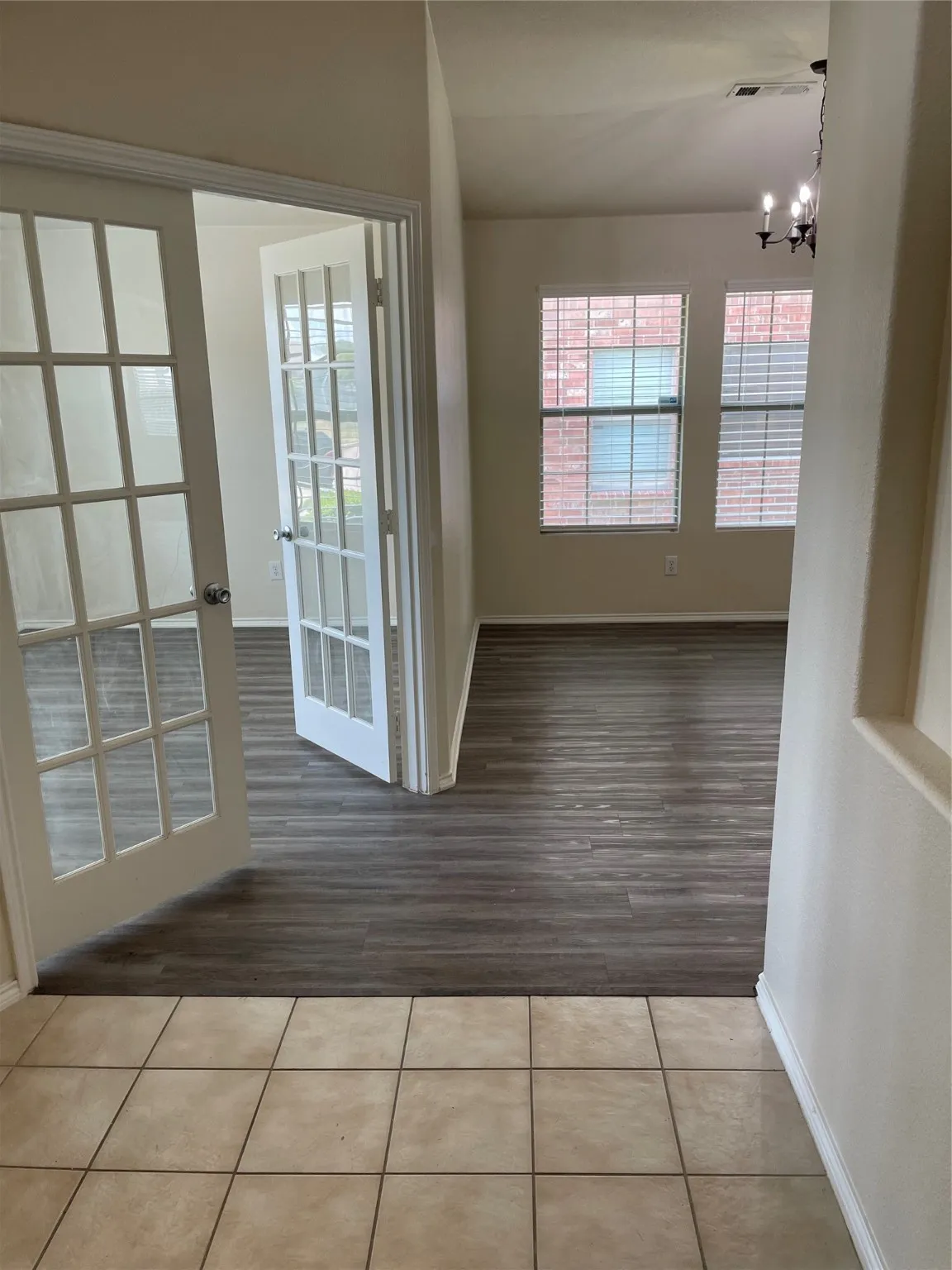Unfurnished room featuring an inviting chandelier and hardwood / wood-style floors