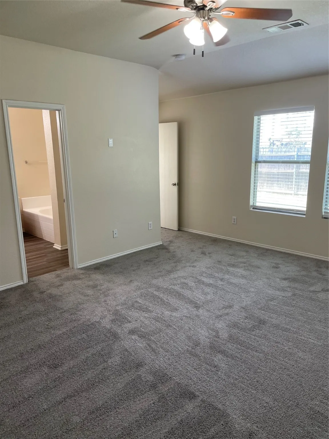 Carpeted spare room featuring ceiling fan