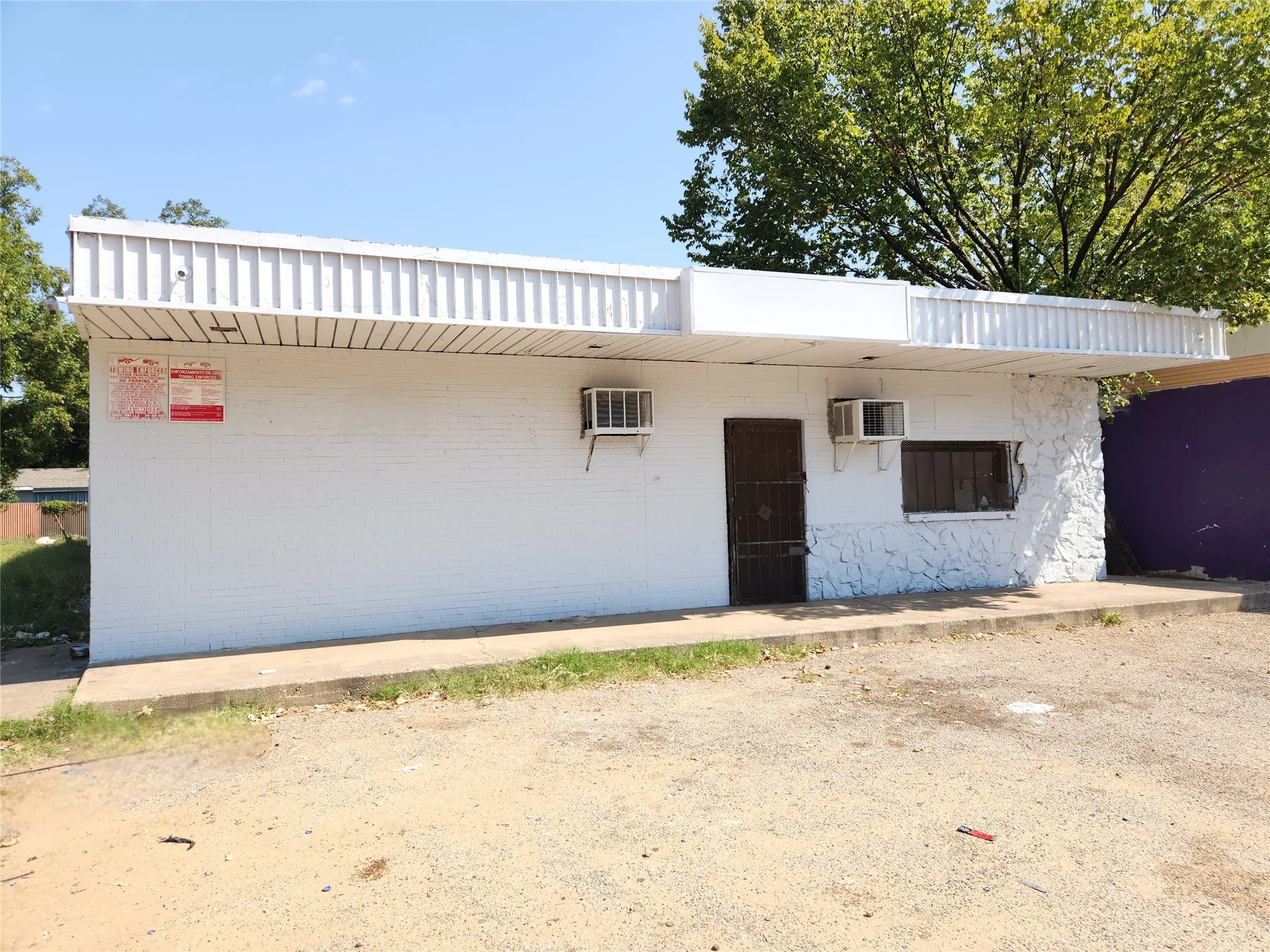 View of front of house featuring an AC wall unit