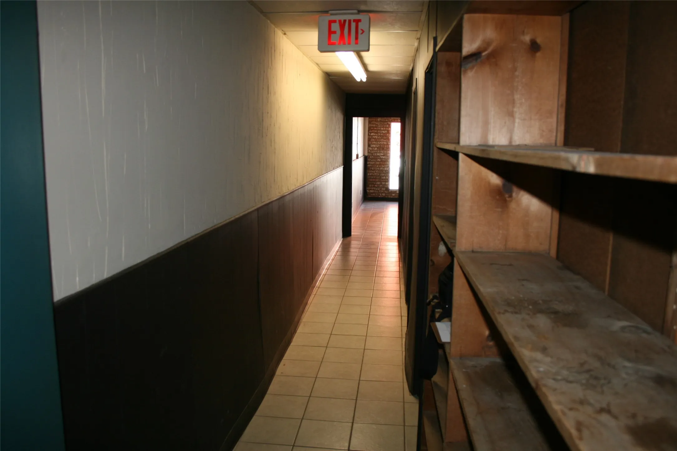 Corridor featuring wooden walls and light tile patterned floors
