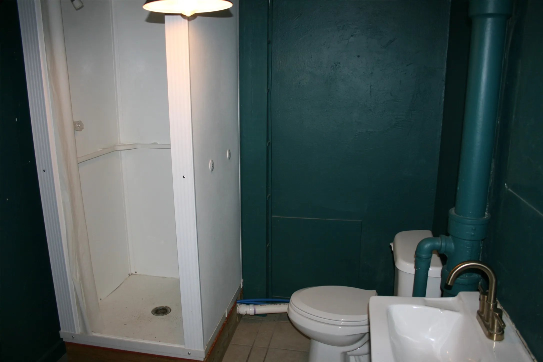 Bathroom with a shower, sink, toilet, and tile patterned floors