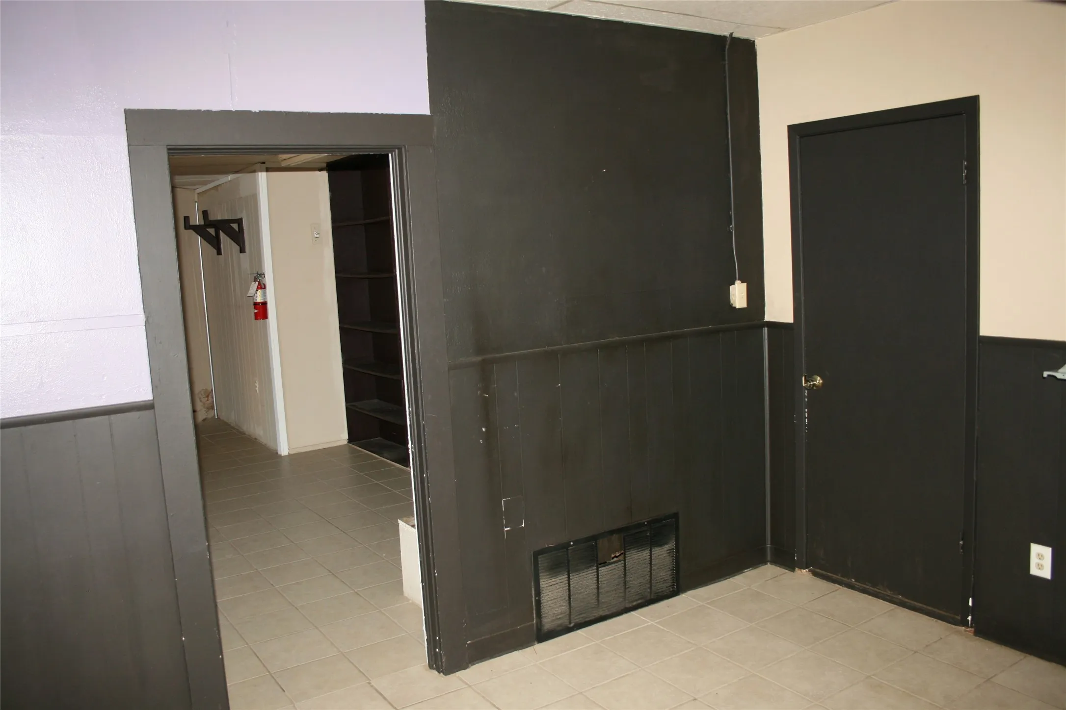Tiled empty room featuring wood walls