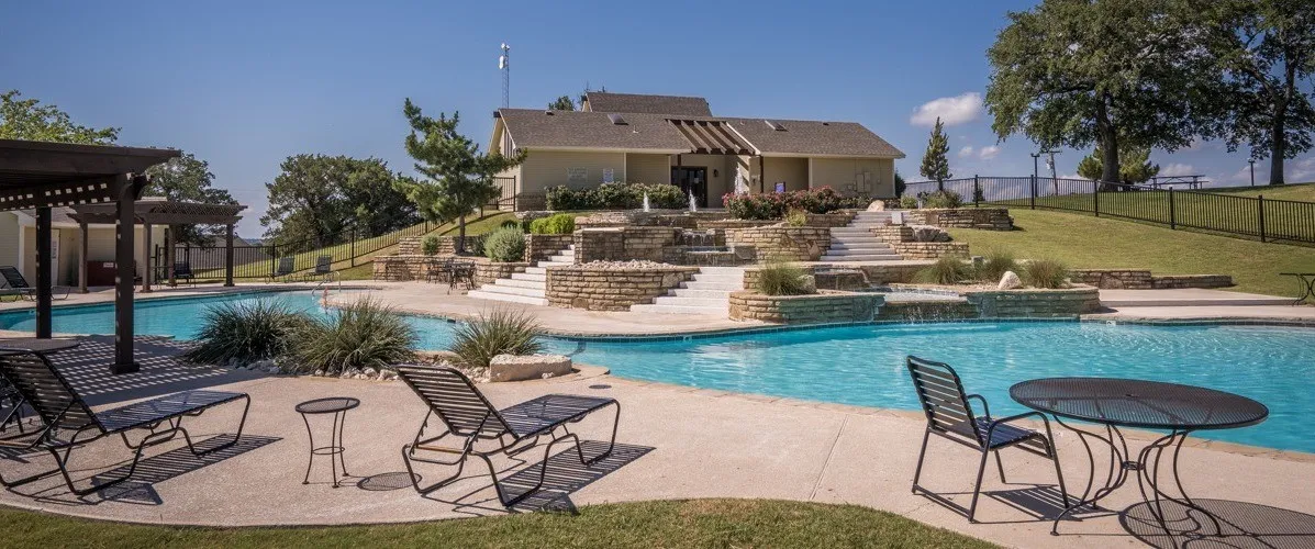 Community pool featuring fence, a lawn, stairs, a pergola, and a patio area