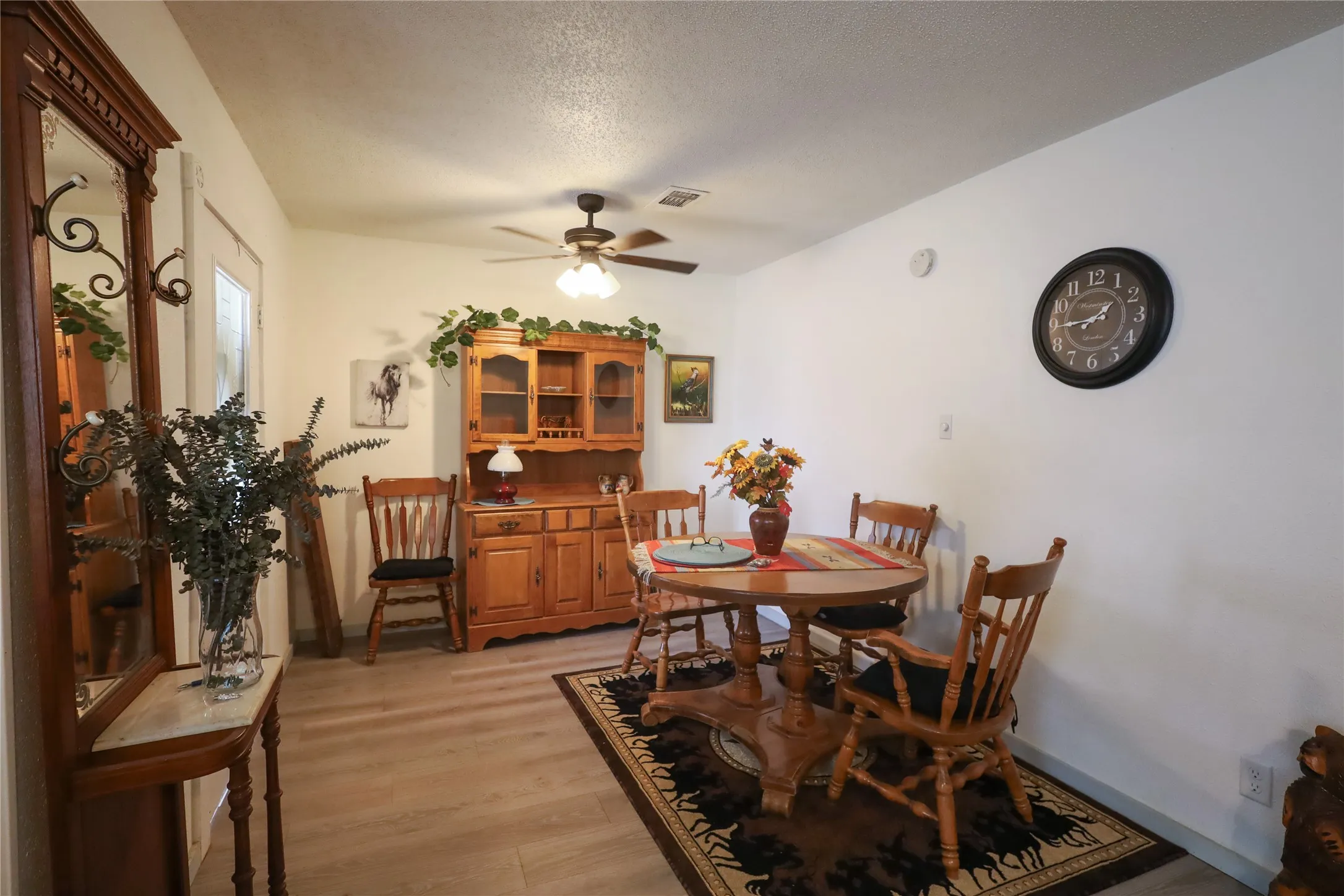 Dining room with light hardwood / wood-style floors, a textured ceiling, and ceiling fan