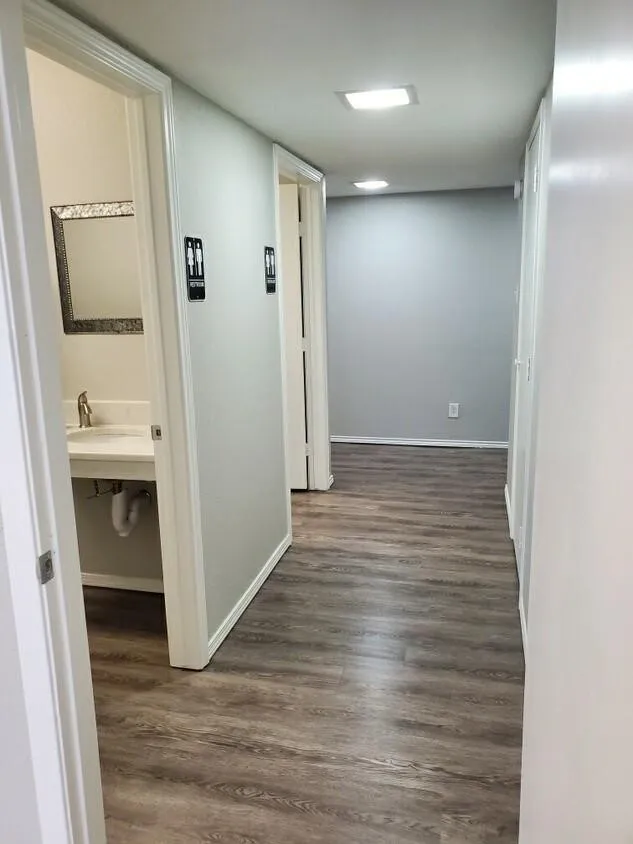 Hall with sink and dark wood-type flooring