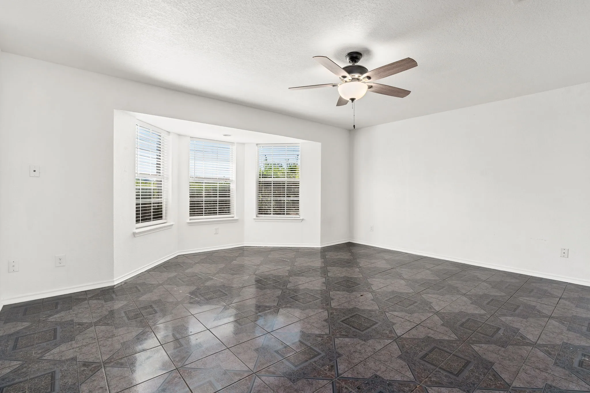 Unfurnished room with a textured ceiling and ceiling fan