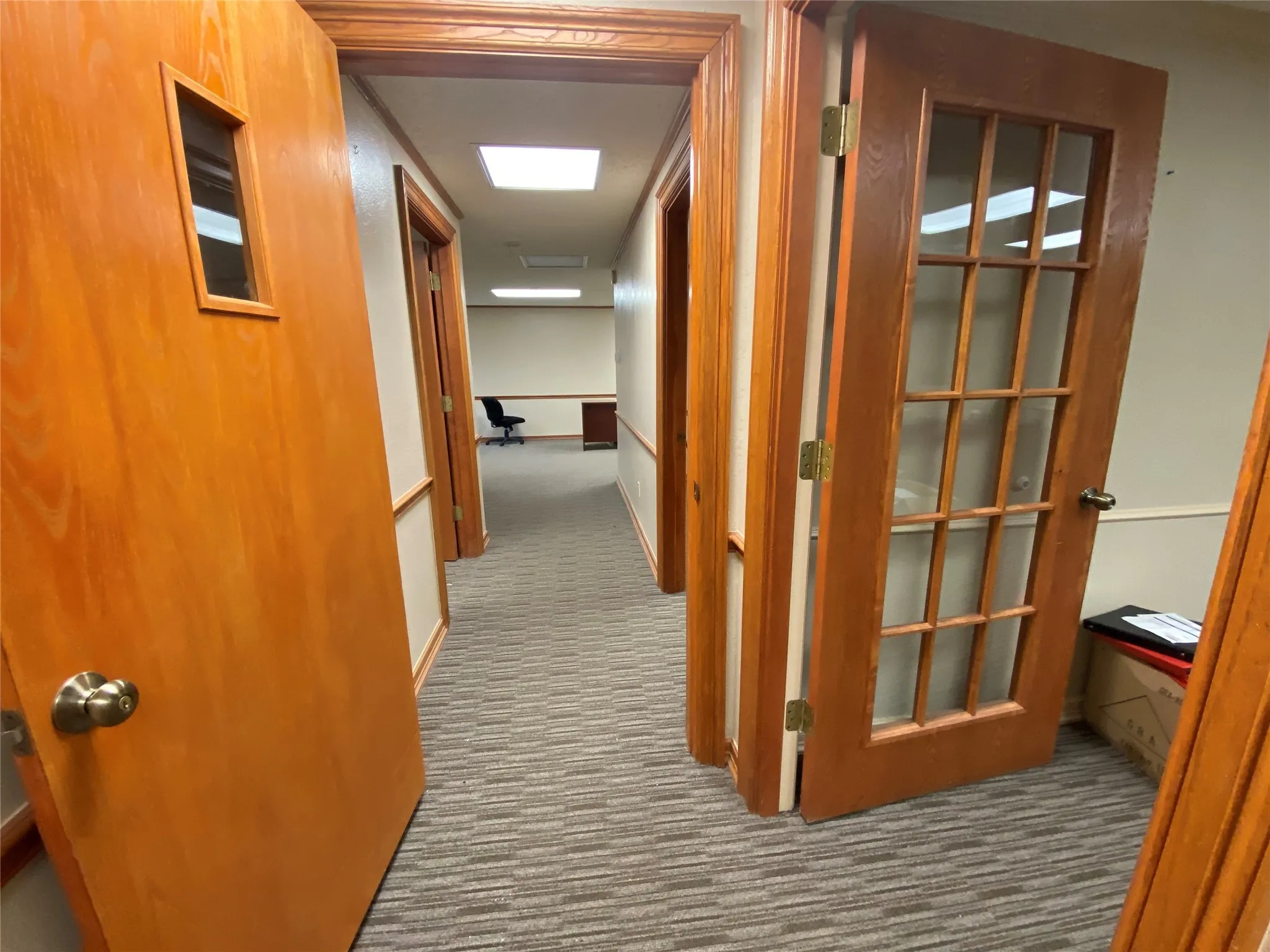 Hall featuring dark colored carpet