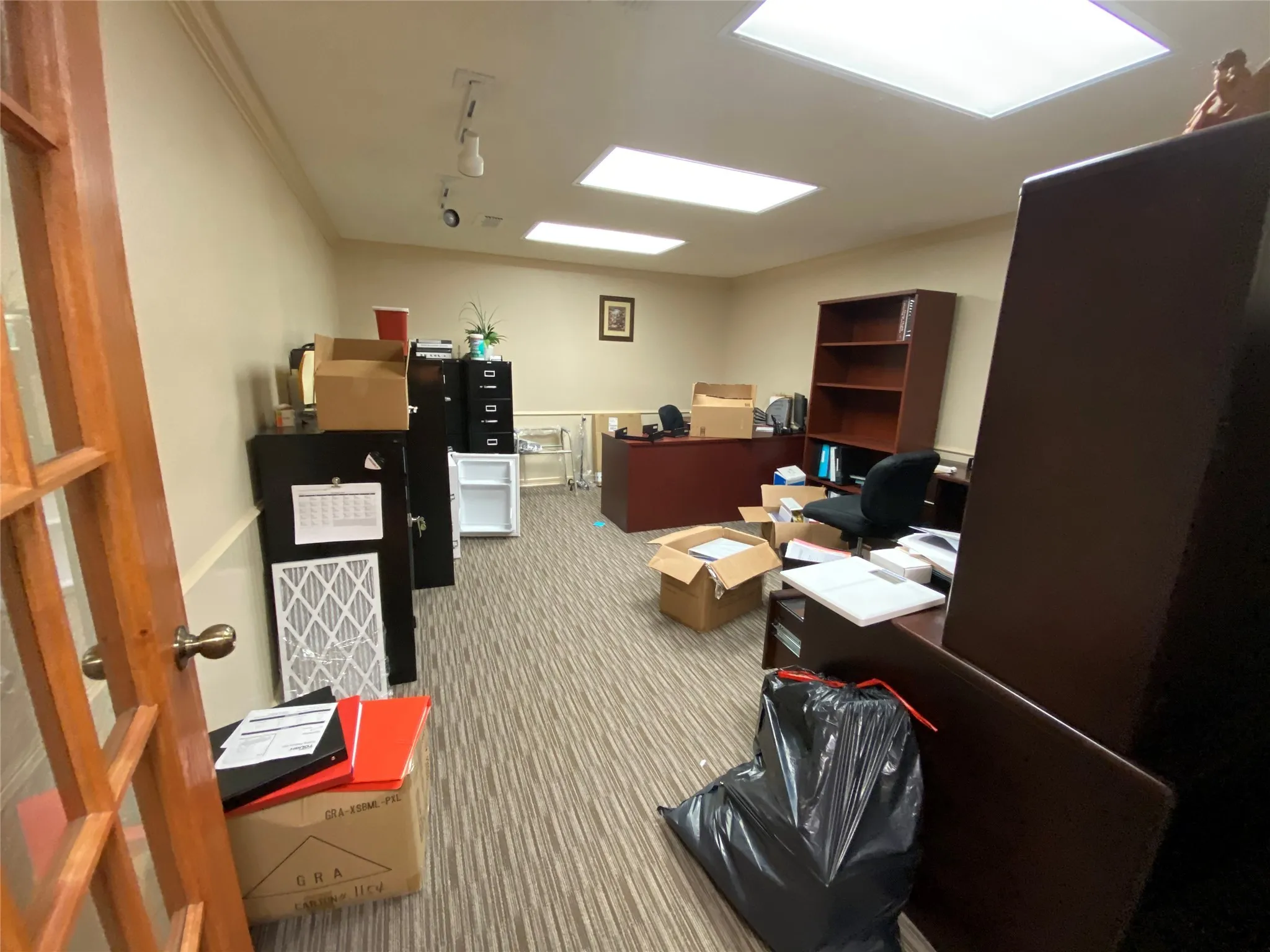 Carpeted home office featuring rail lighting