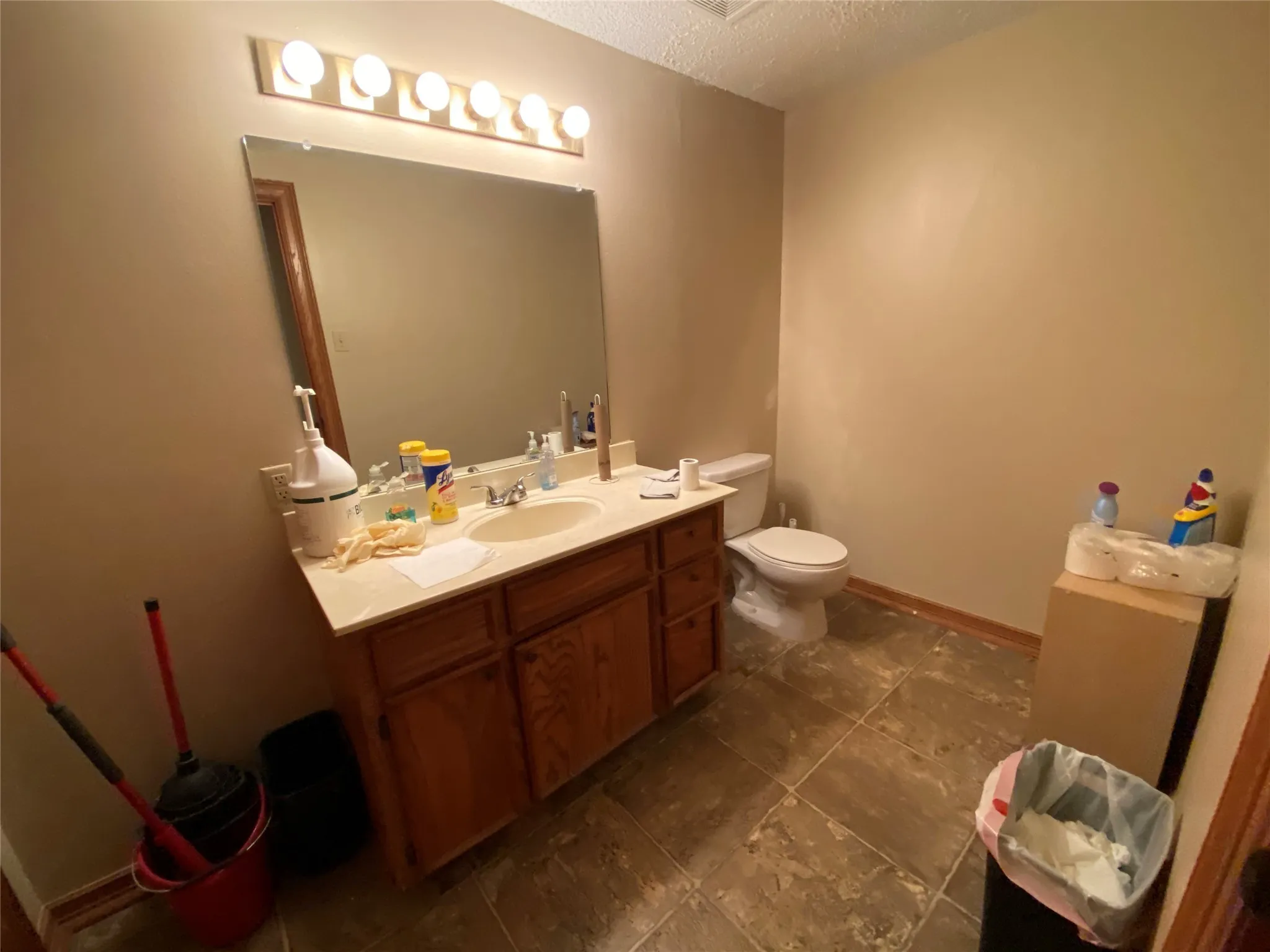 Bathroom with vanity, toilet, and a textured ceiling