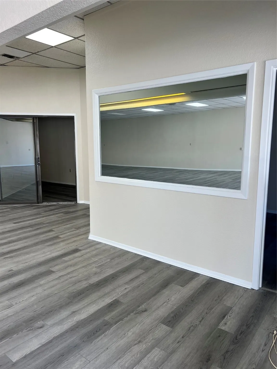 Unfurnished room featuring a paneled ceiling and dark wood-type flooring