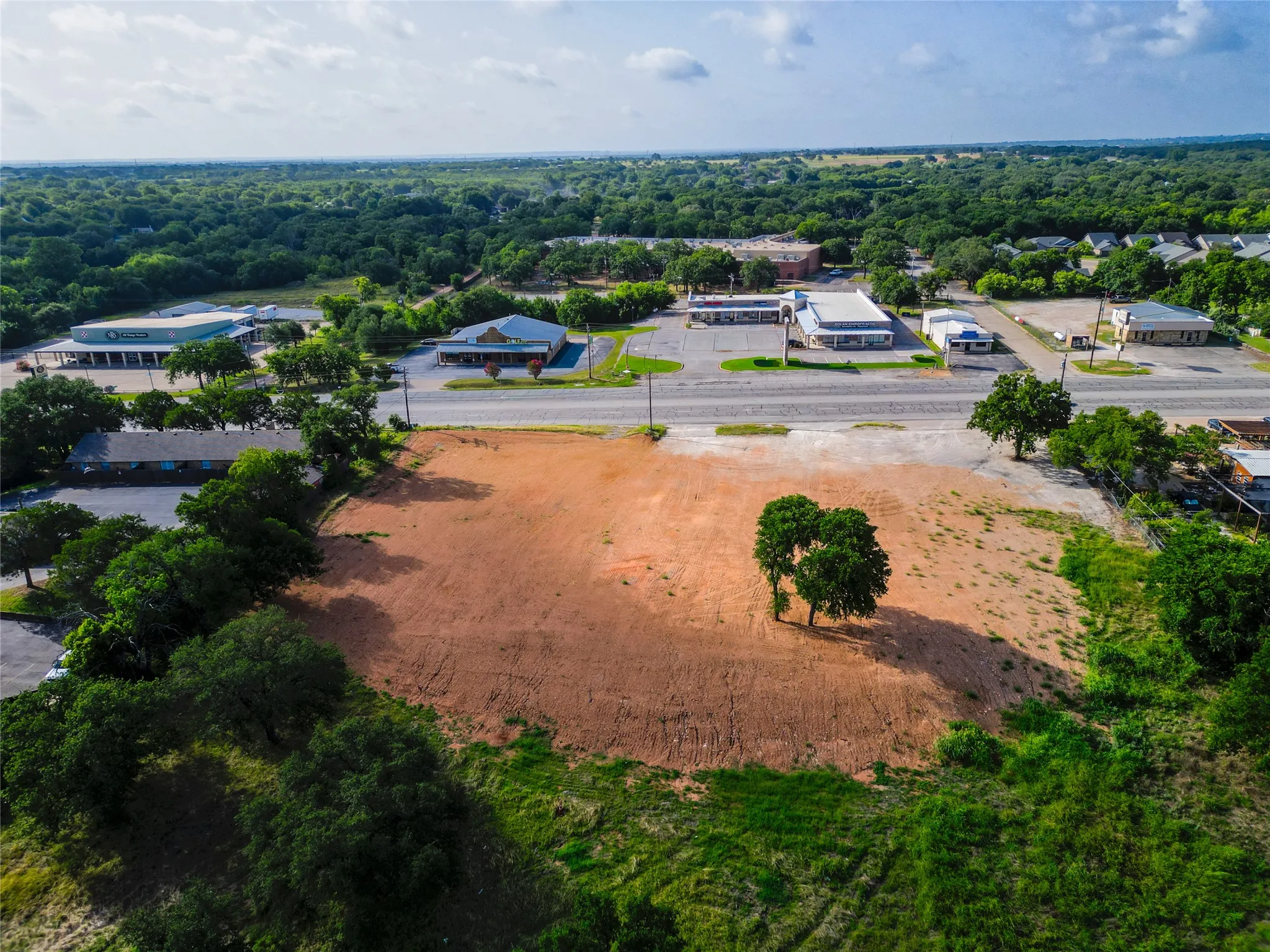 Cleared parcel featuring established trees and direct road frontage