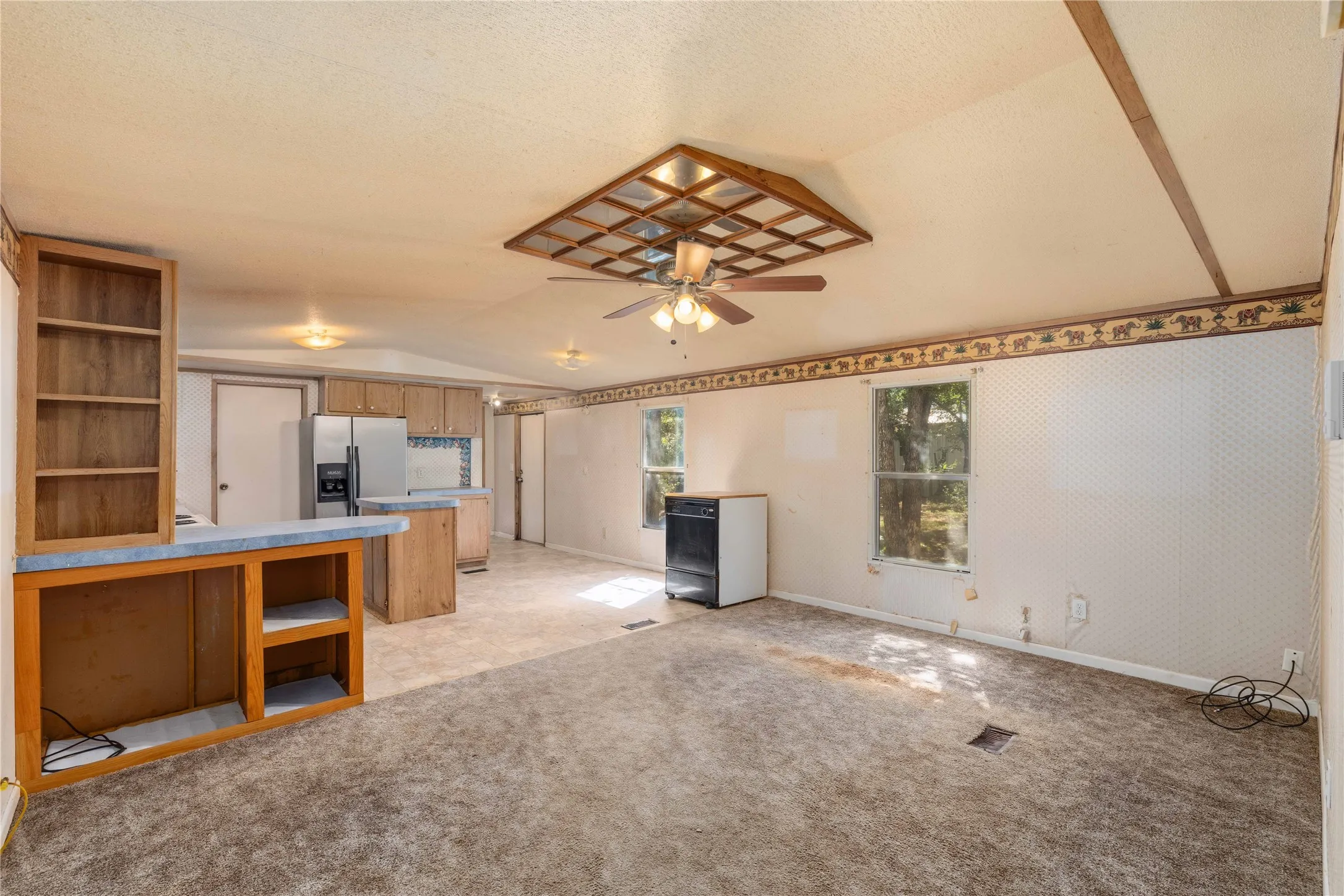 Open-concept living space with partial carpeting and tile flooring