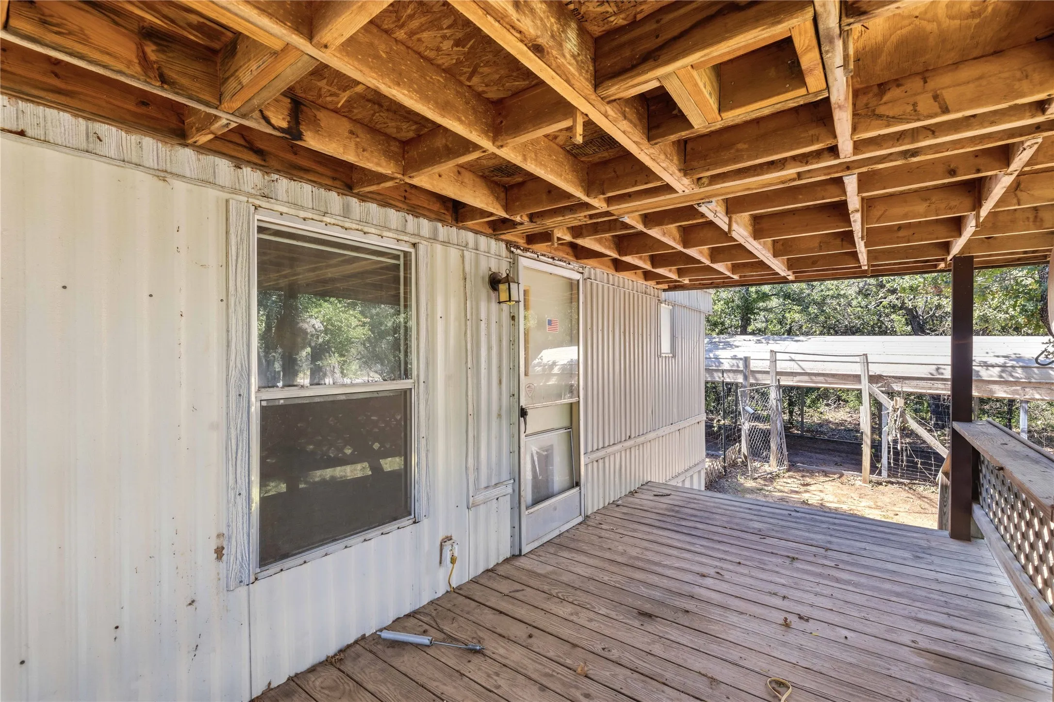 Covered exterior deck featuring wood plank flooring and an exposed wood joist ceiling