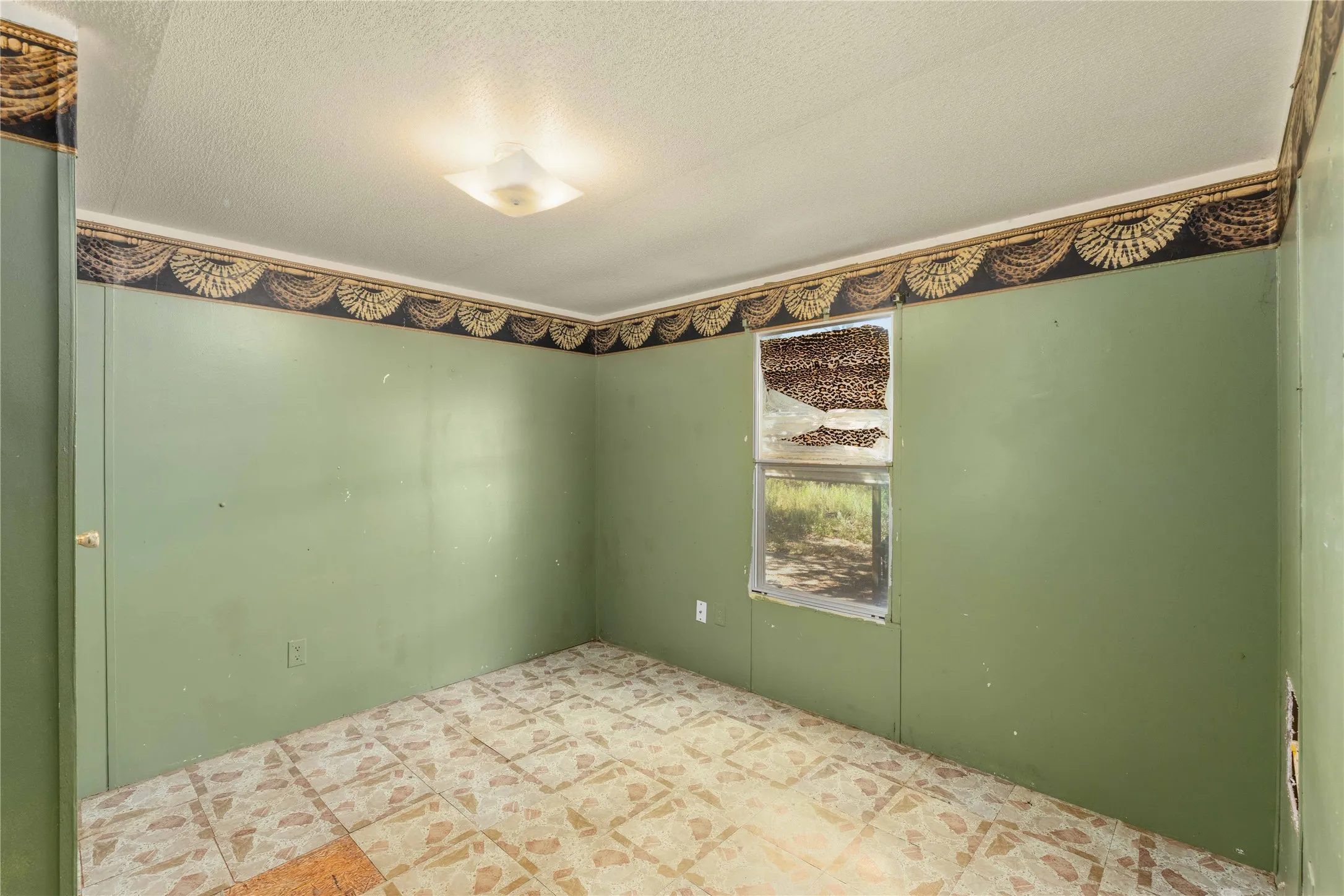 Interior room featuring patterned floor tiles, light green walls, and a decorative border