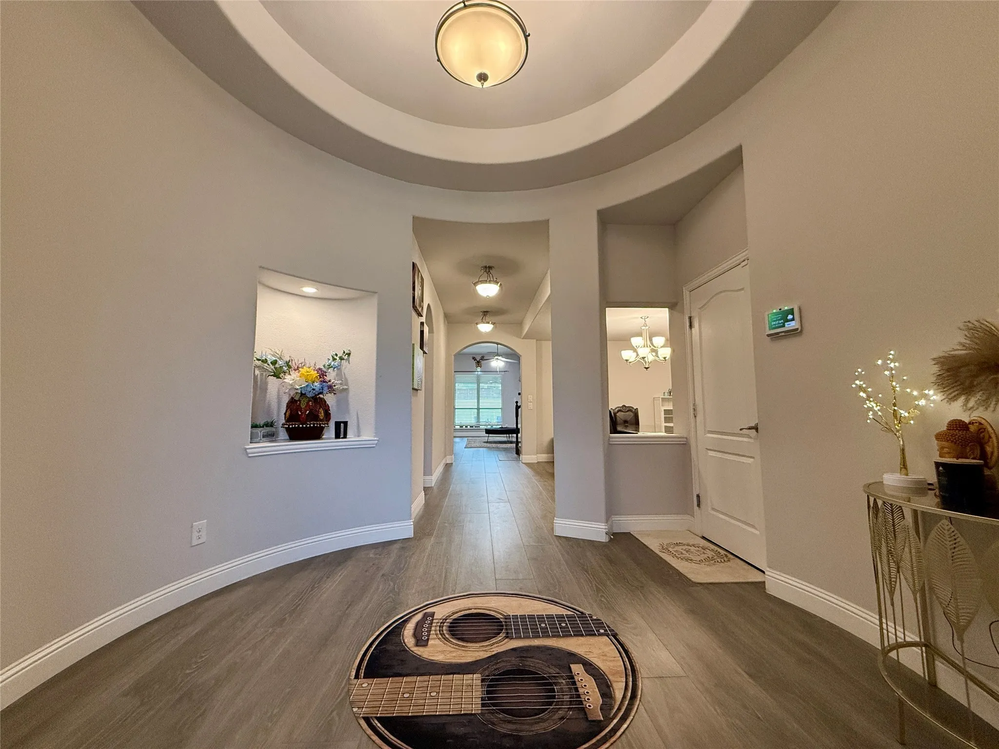 Corridor featuring a tray ceiling, wood-laminate flooring