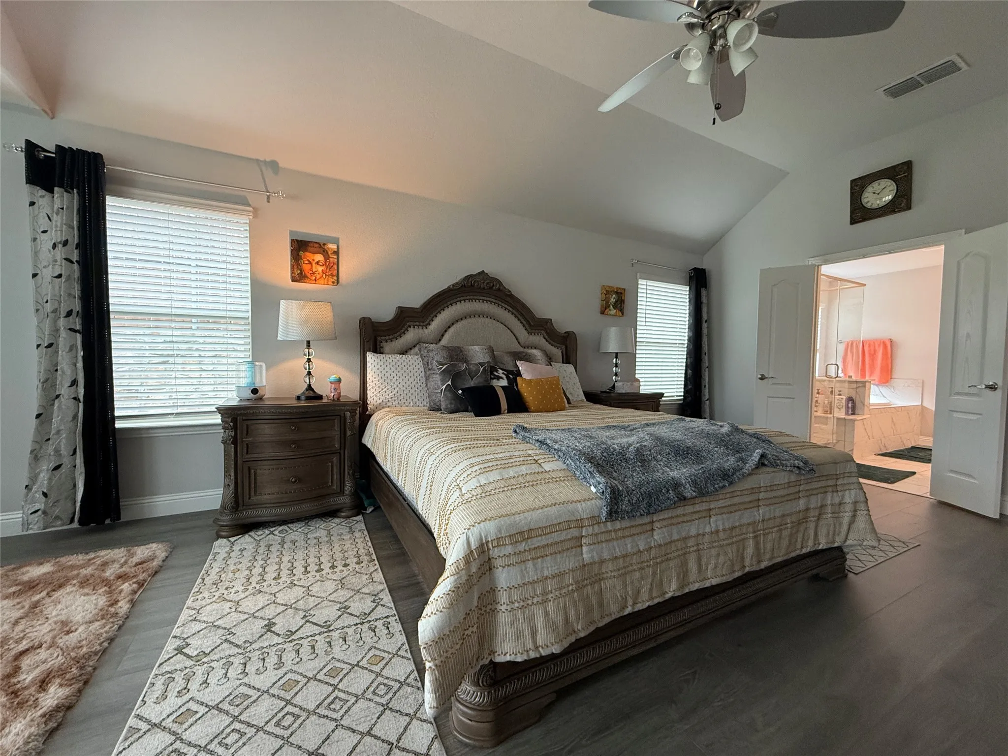 Primary Bedroom featuring high ceiling,  wood-laminate style floors, ensuite bathroom, and ceiling fan