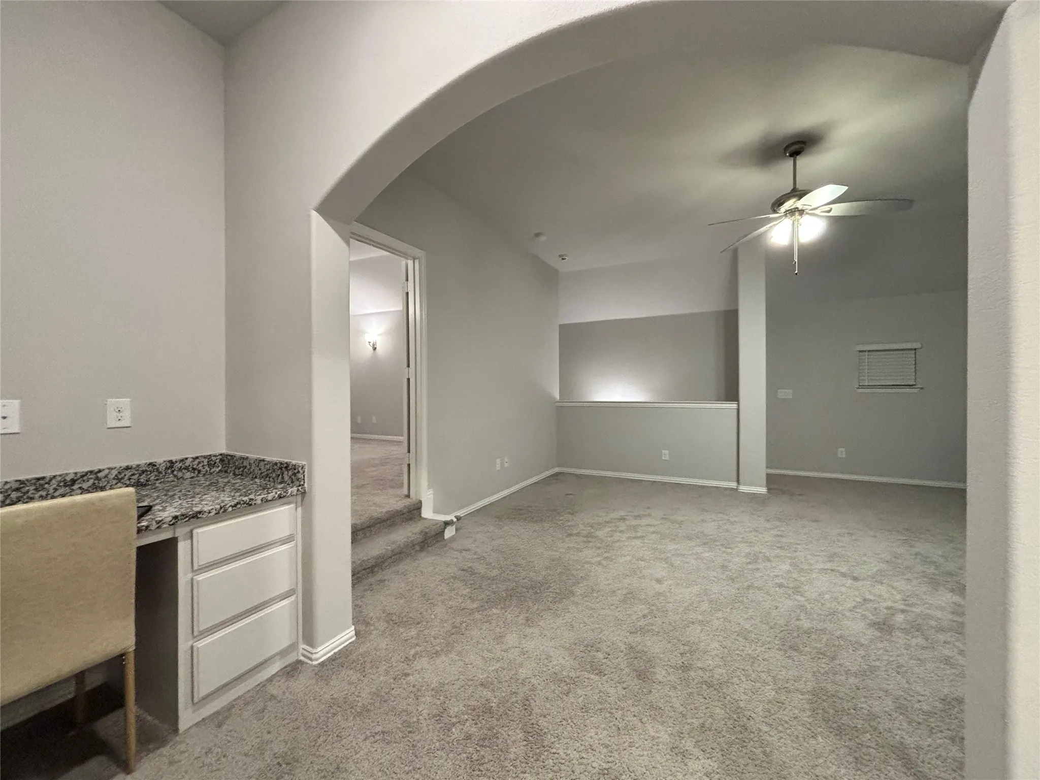 Unfurnished living room featuring light carpet and ceiling fan