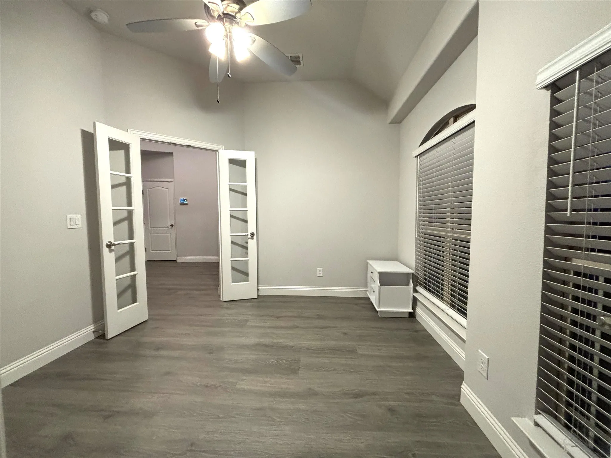 Unfurnished bedroom with lofted ceiling, french doors, ceiling fan, and dark hardwood / wood-style floors