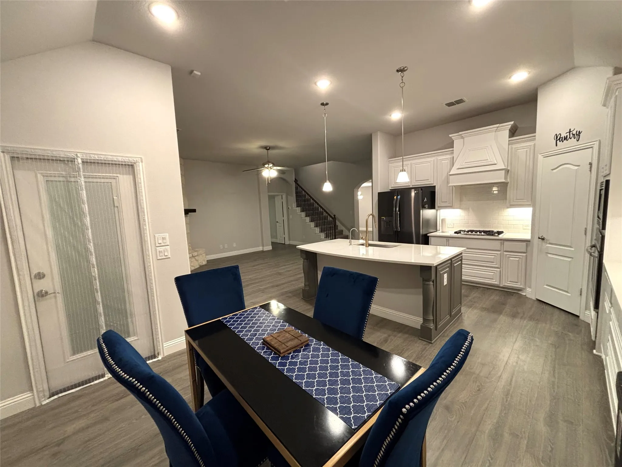Dining room featuring ceiling fan, dark hardwood / wood-style flooring, lofted ceiling, and sink