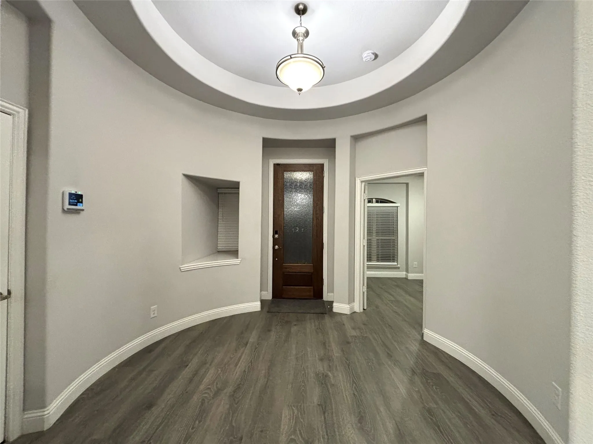 Entrance foyer with a raised ceiling and dark hardwood / wood-style flooring