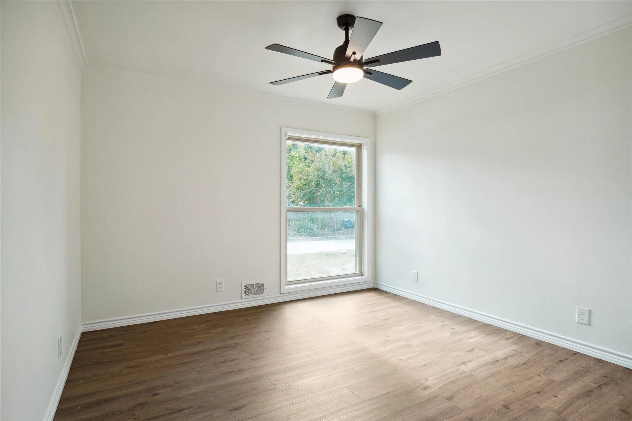 Spare room with ornamental molding, hardwood / wood-style floors, and ceiling fan