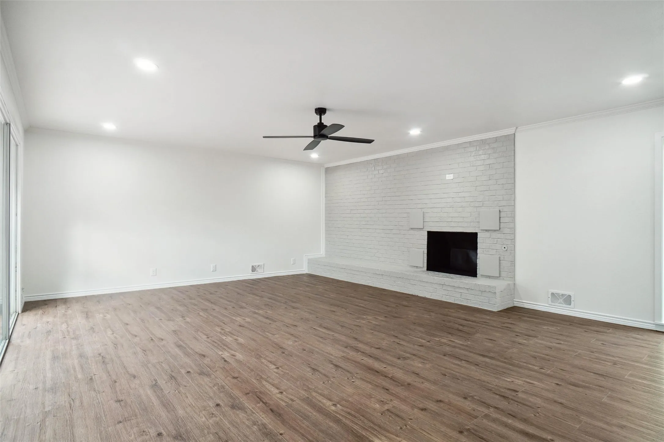 Unfurnished living room with ornamental molding, a fireplace, and dark hardwood / wood-style flooring