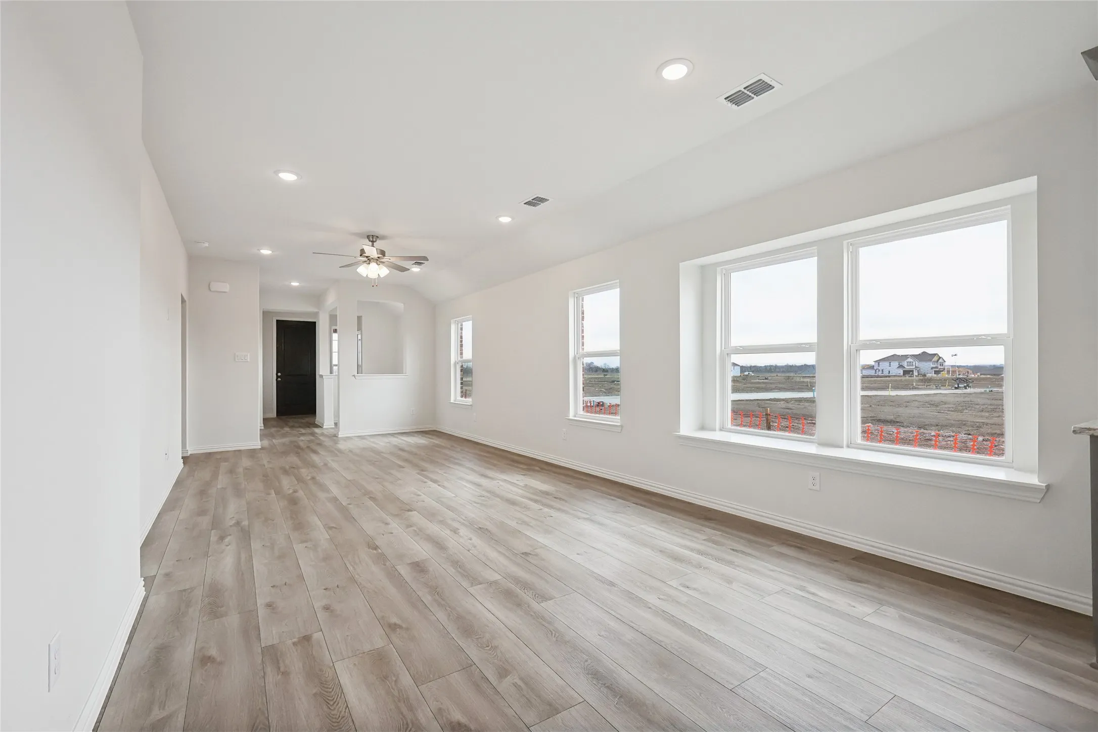 Unfurnished living room with light hardwood / wood-style floors and ceiling fan