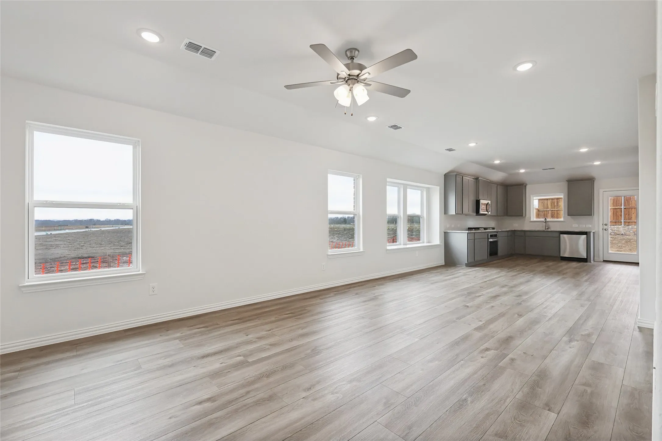 Unfurnished living room featuring sink, light hardwood / wood-style floors, and ceiling fan