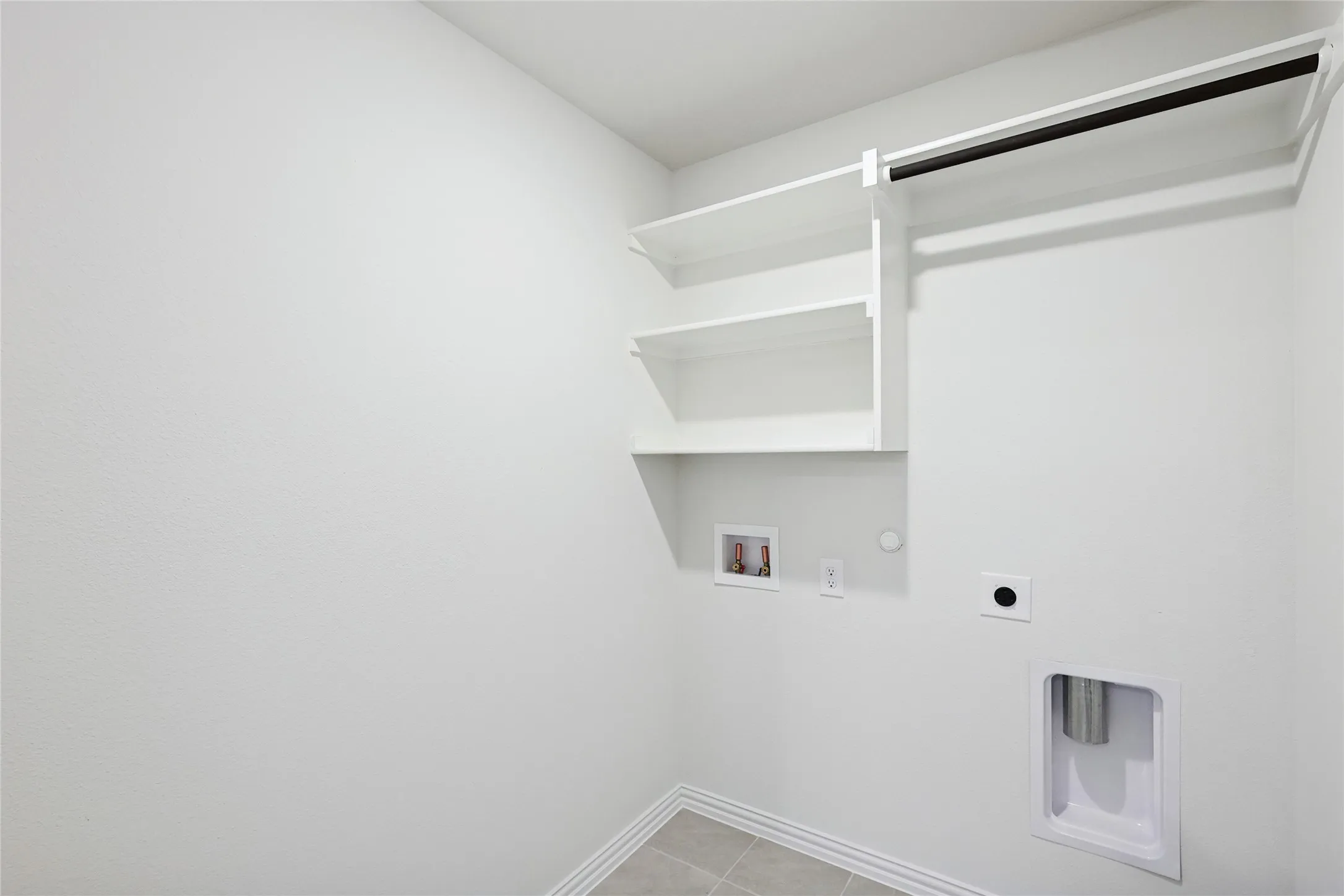 Laundry room with light tile patterned floors, hookup for a gas dryer, hookup for a washing machine, and electric dryer hookup