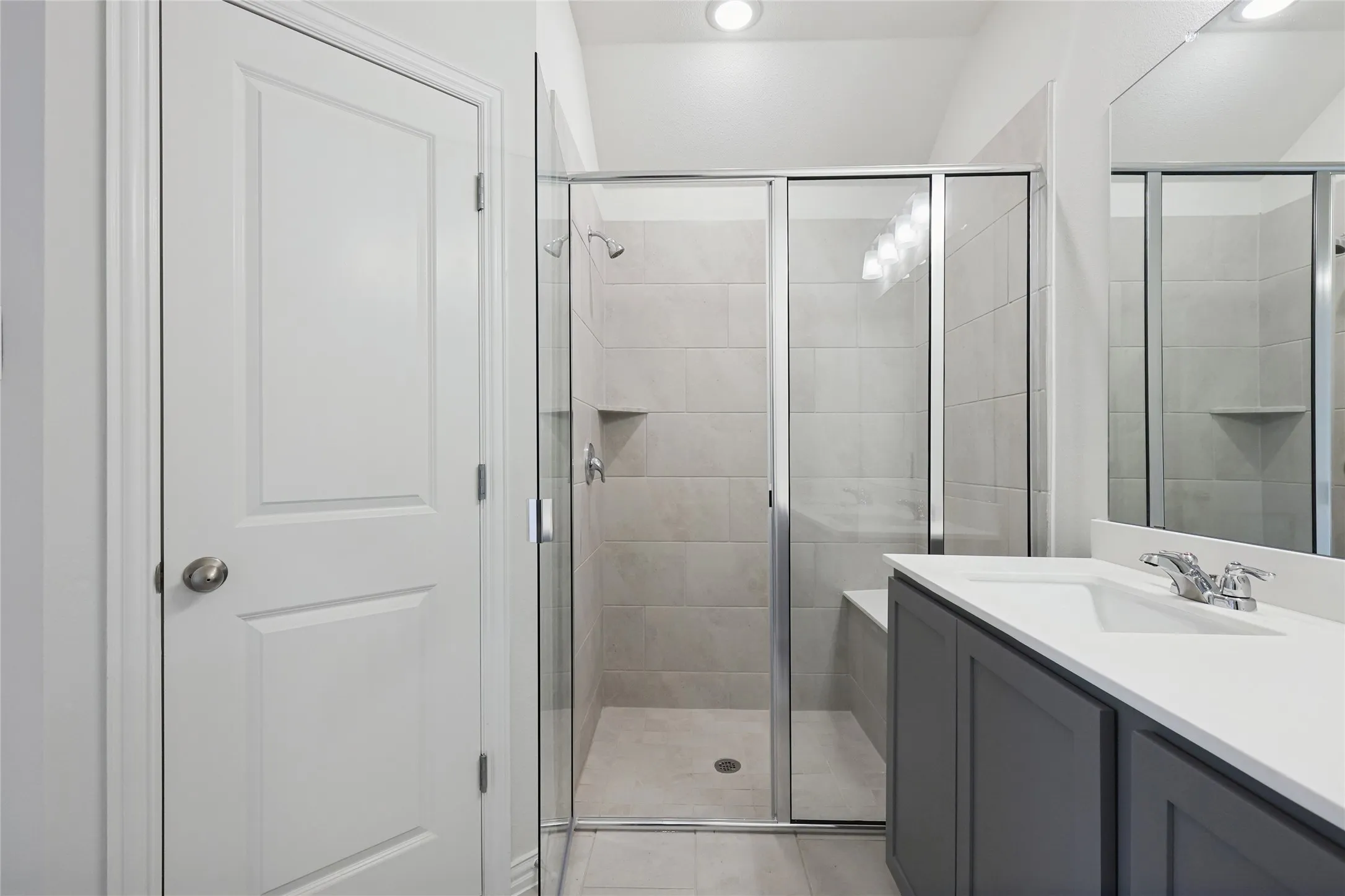 Bathroom with vanity, an enclosed shower, and tile patterned floors