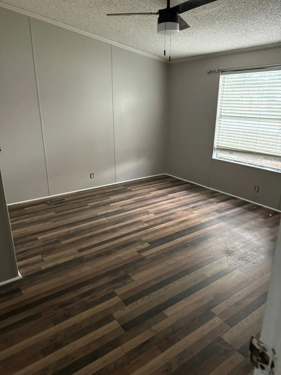 Unfurnished room featuring dark hardwood / wood-style flooring, a textured ceiling, ceiling fan, and crown molding