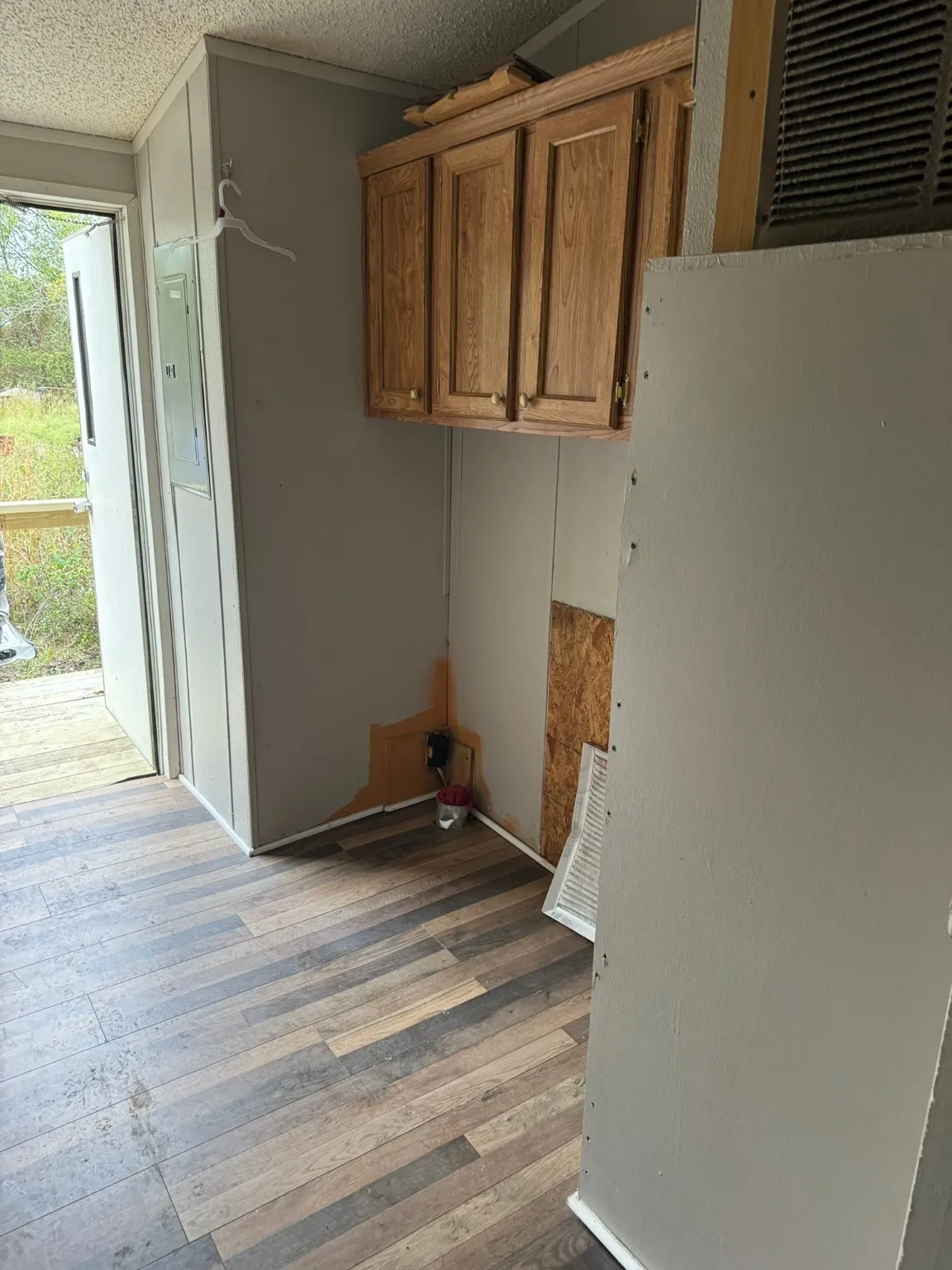 Washroom featuring electric panel, a textured ceiling, and light hardwood / wood-style flooring