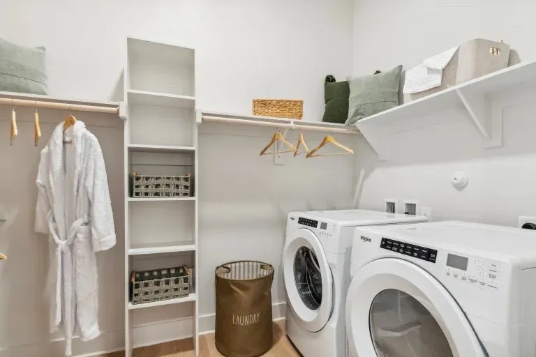 Laundry area featuring wood-type flooring and independent washer and dryer