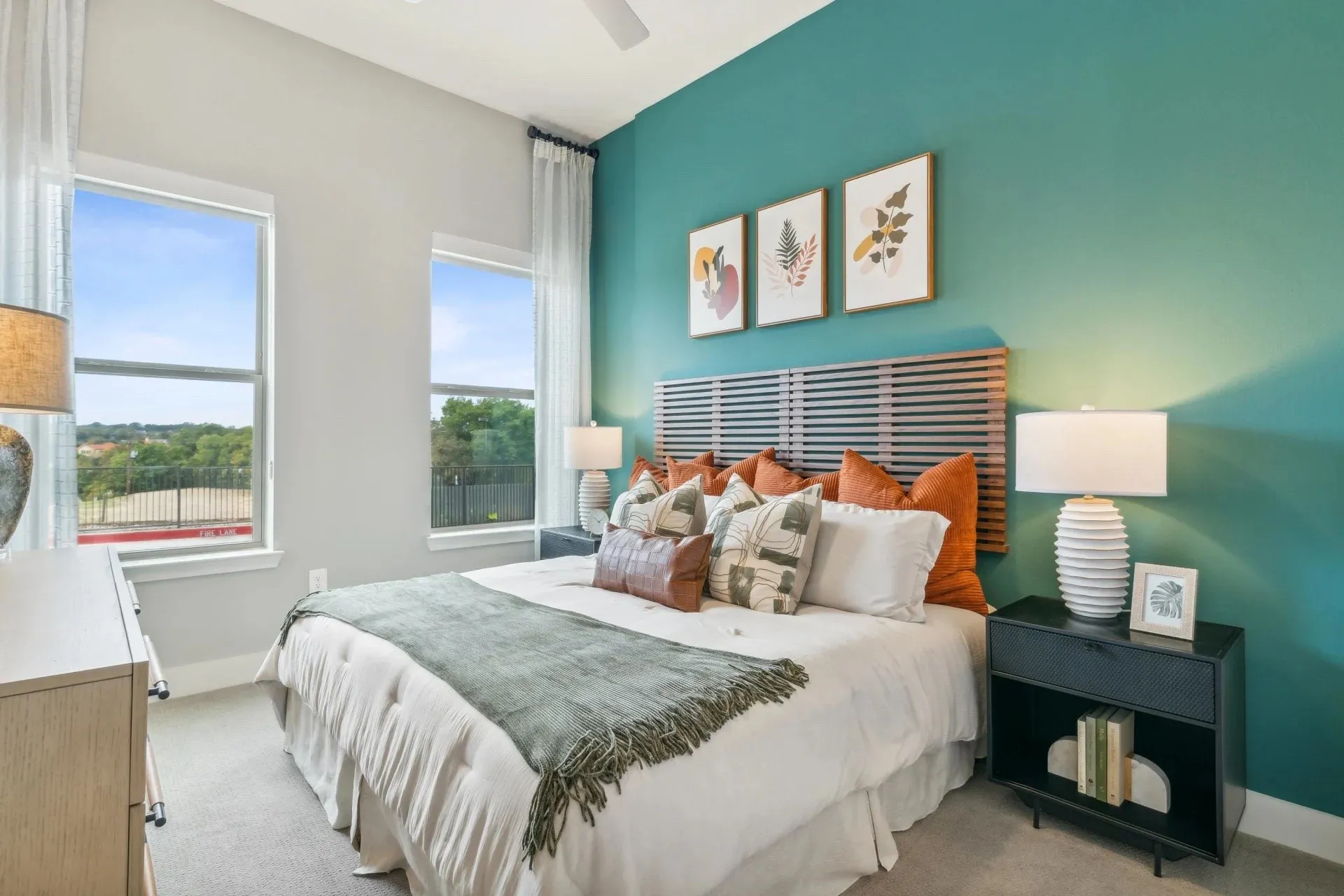 Carpeted bedroom with ceiling fan and multiple windows