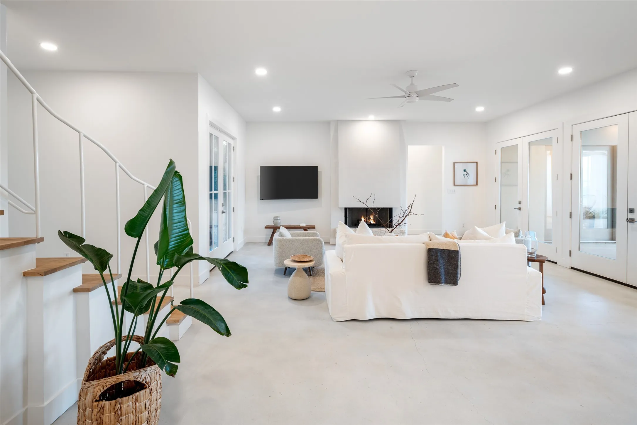 Living room with french doors, a large fireplace, and ceiling fan