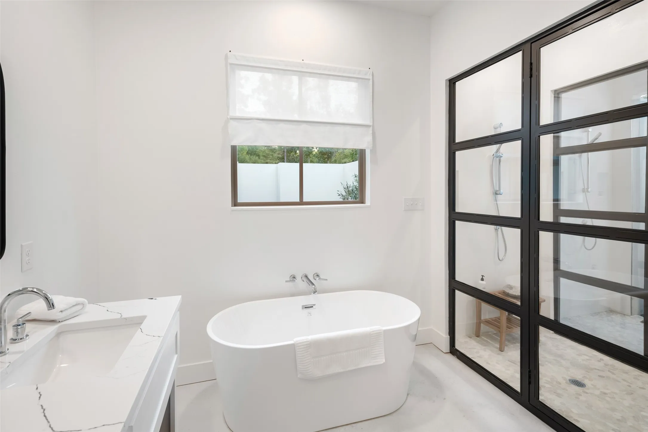 Bathroom featuring concrete floors, vanity, and a tub to relax in