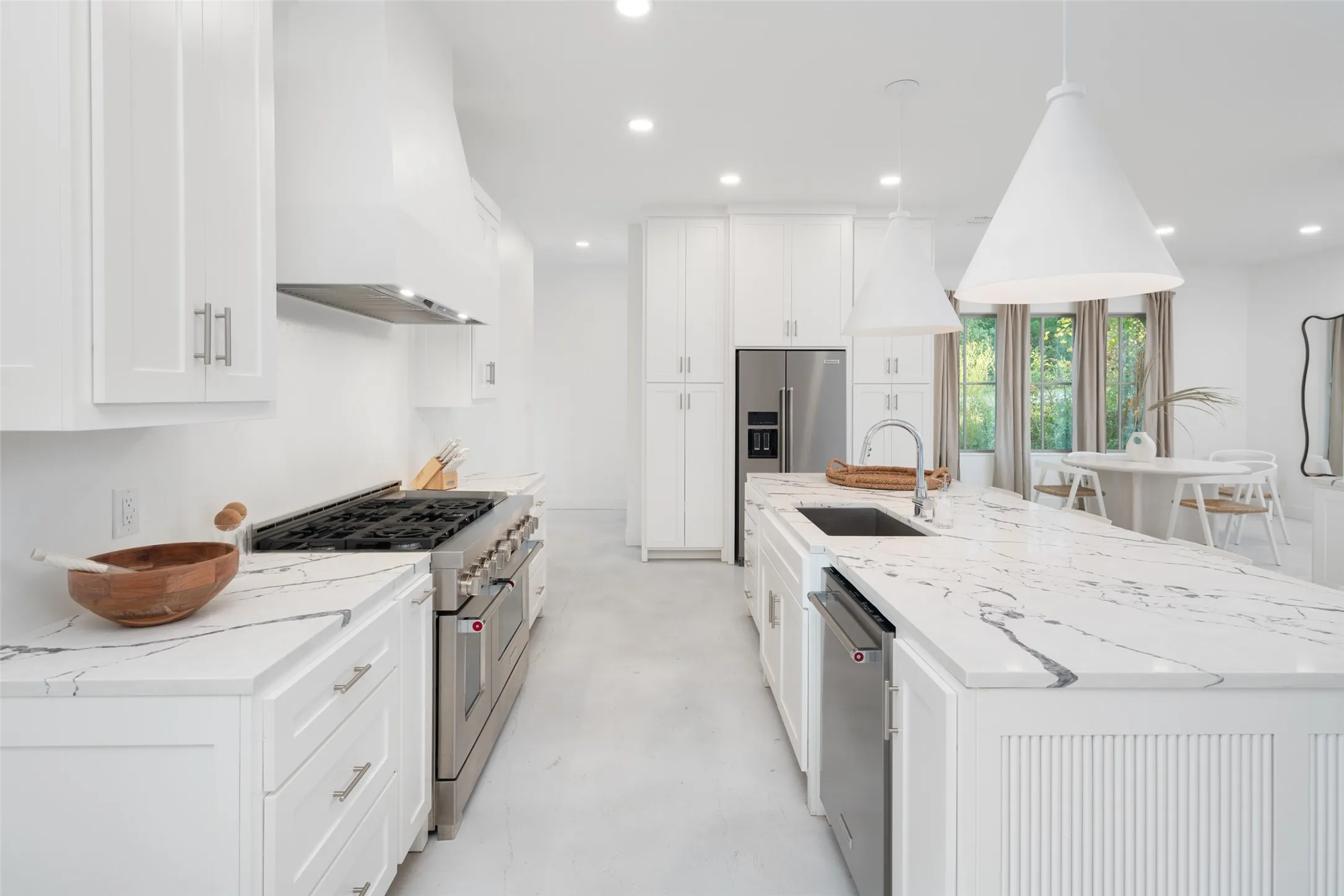 Kitchen featuring appliances with stainless steel finishes, sink, custom exhaust hood, and white cabinets