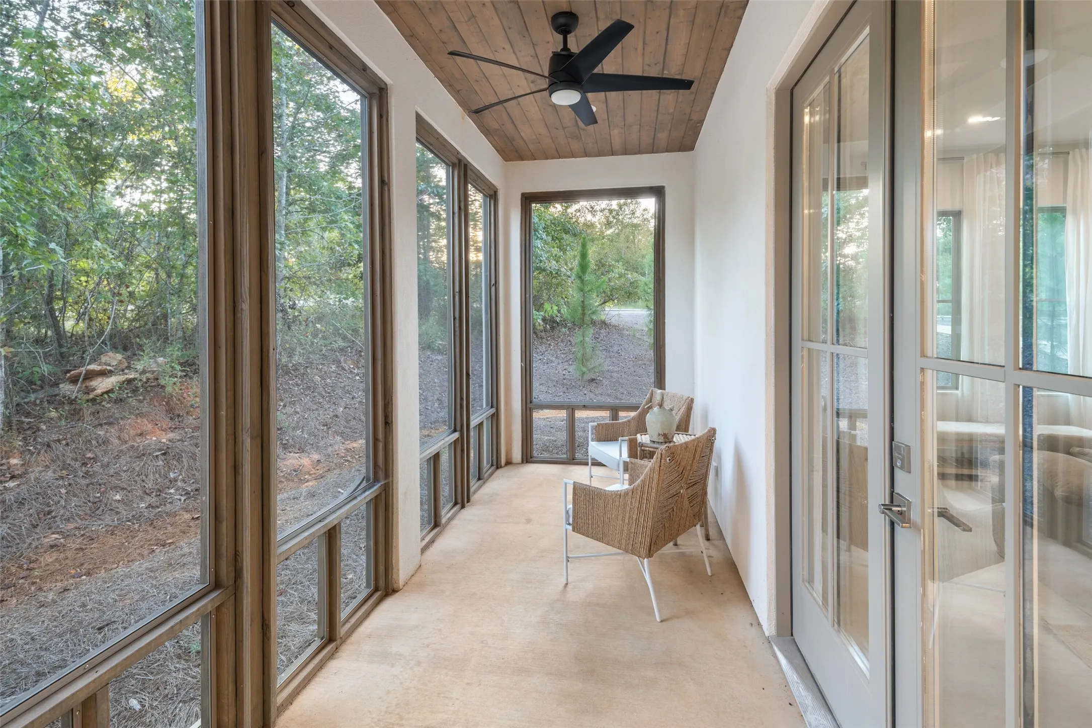 Unfurnished sunroom featuring french doors, wood ceiling, plenty of natural light, and ceiling fan