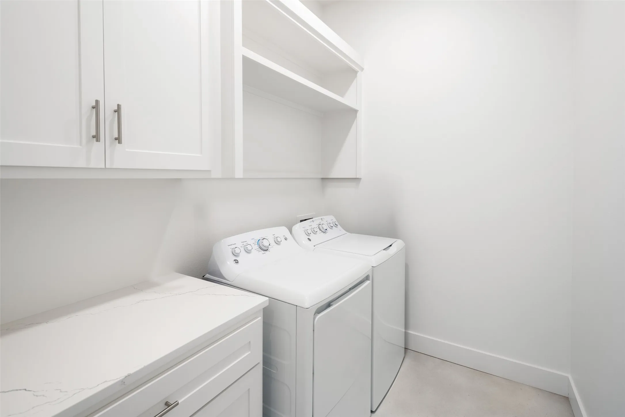 Washroom with cabinets and separate washer and dryer