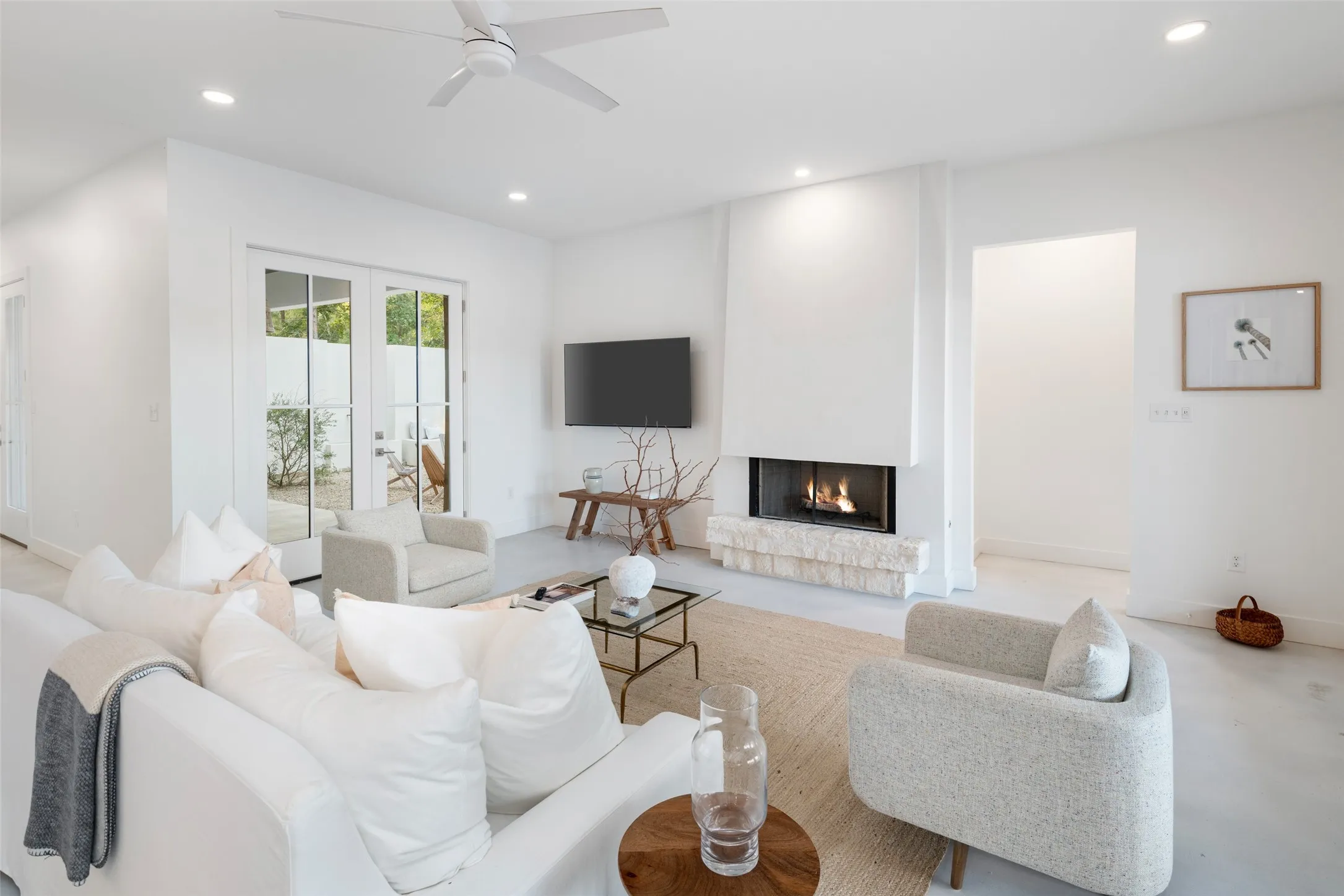 Living room featuring a large fireplace and ceiling fan