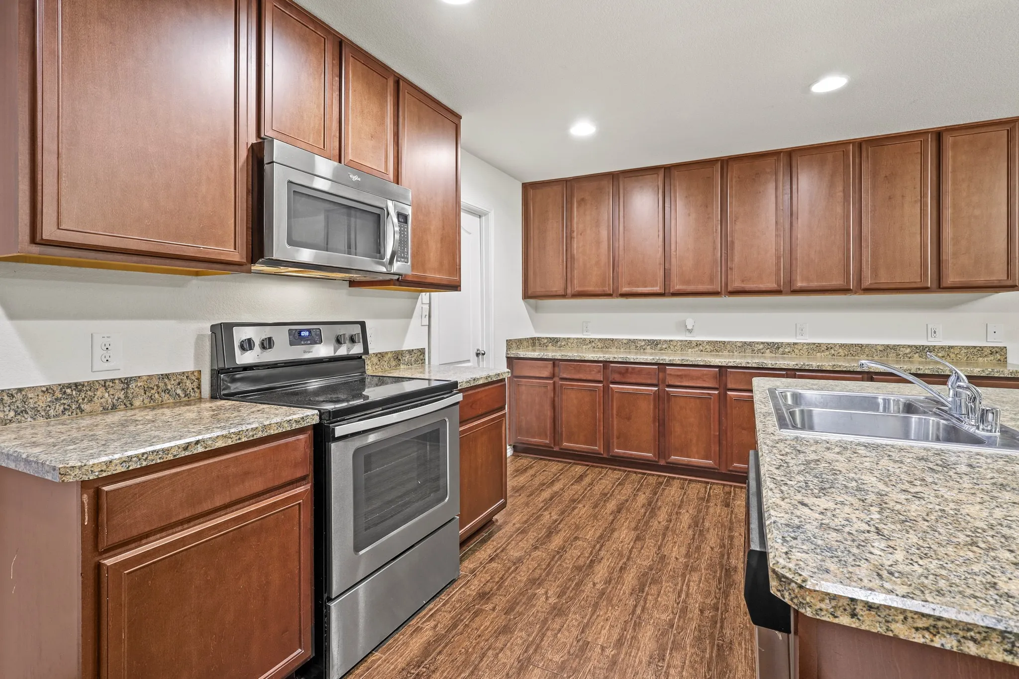 Kitchen featuring appliances with stainless steel finishes, dark hardwood / wood-style floors, and sink