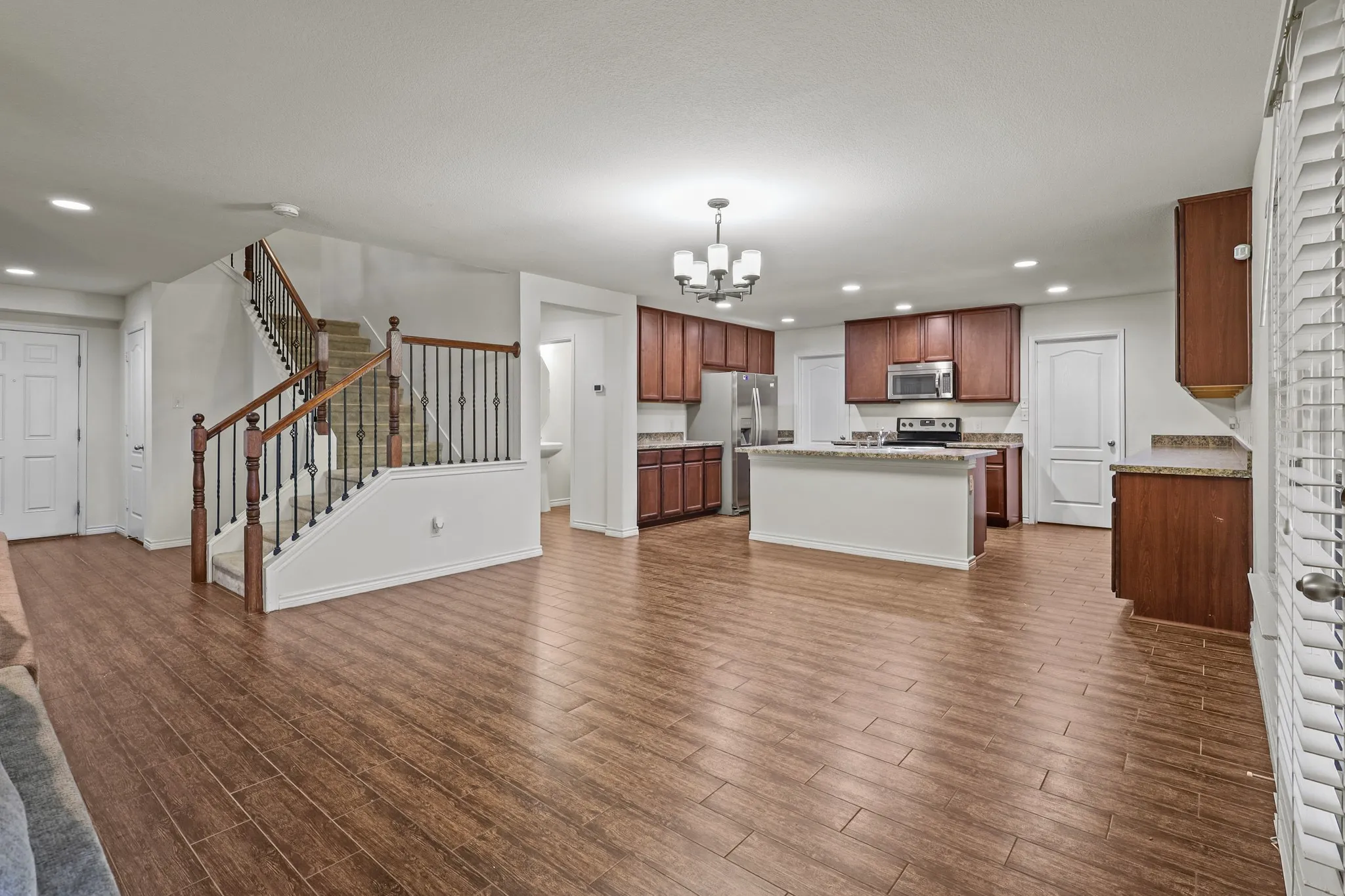 Unfurnished living room with dark hardwood / wood-style flooring and a notable chandelier