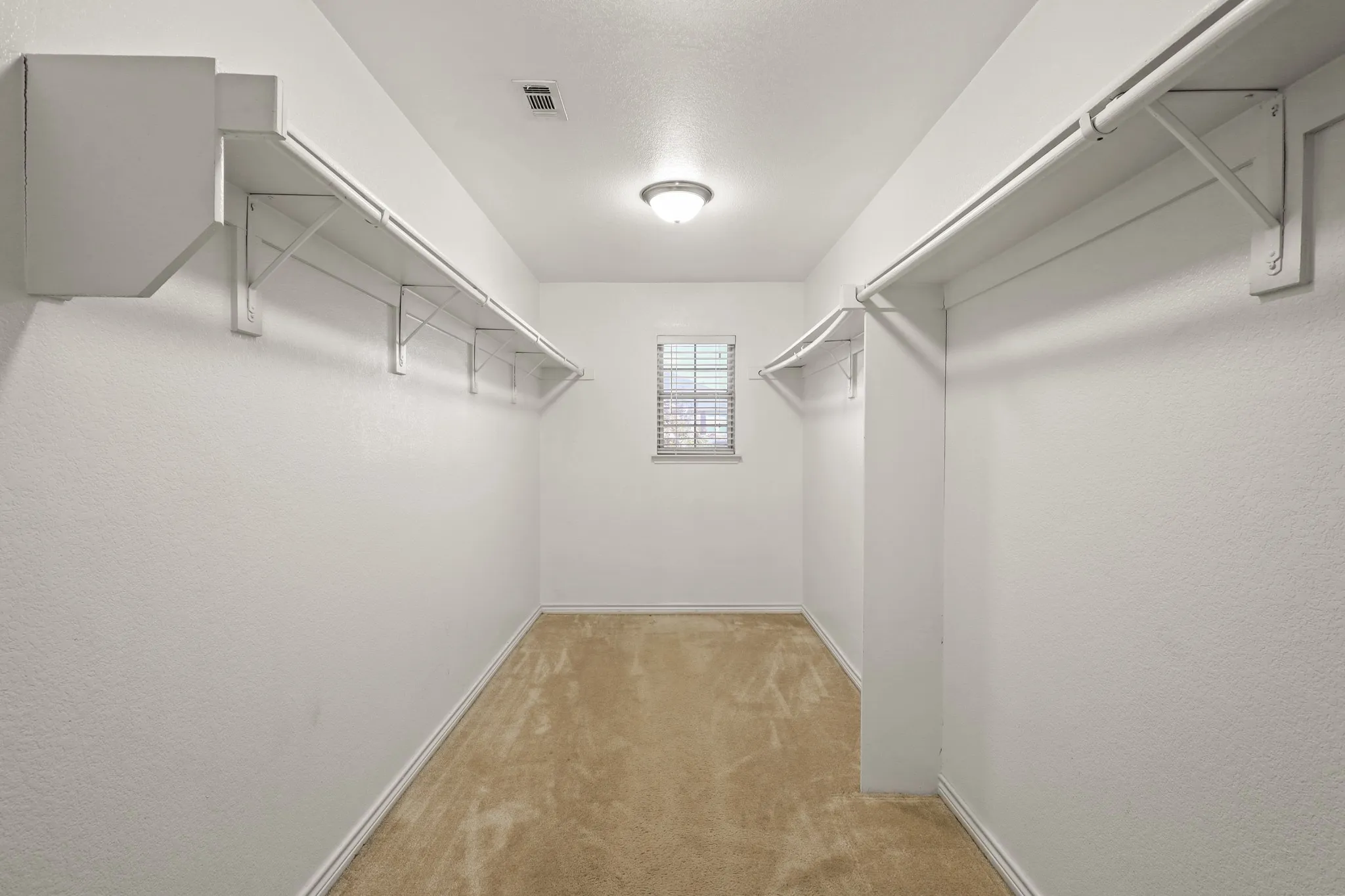 Spacious closet with light colored carpet