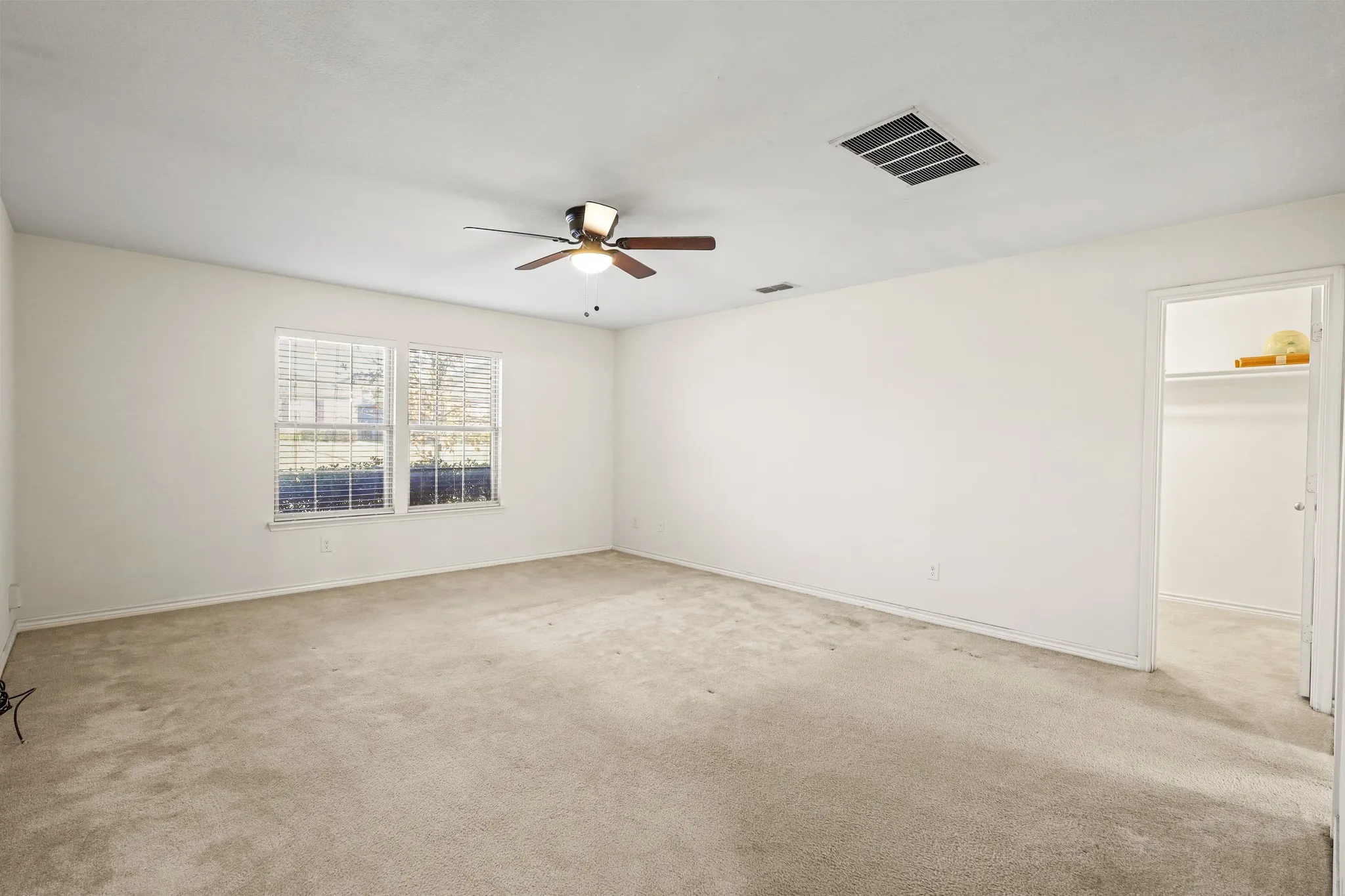 Carpeted empty room with ceiling fan
