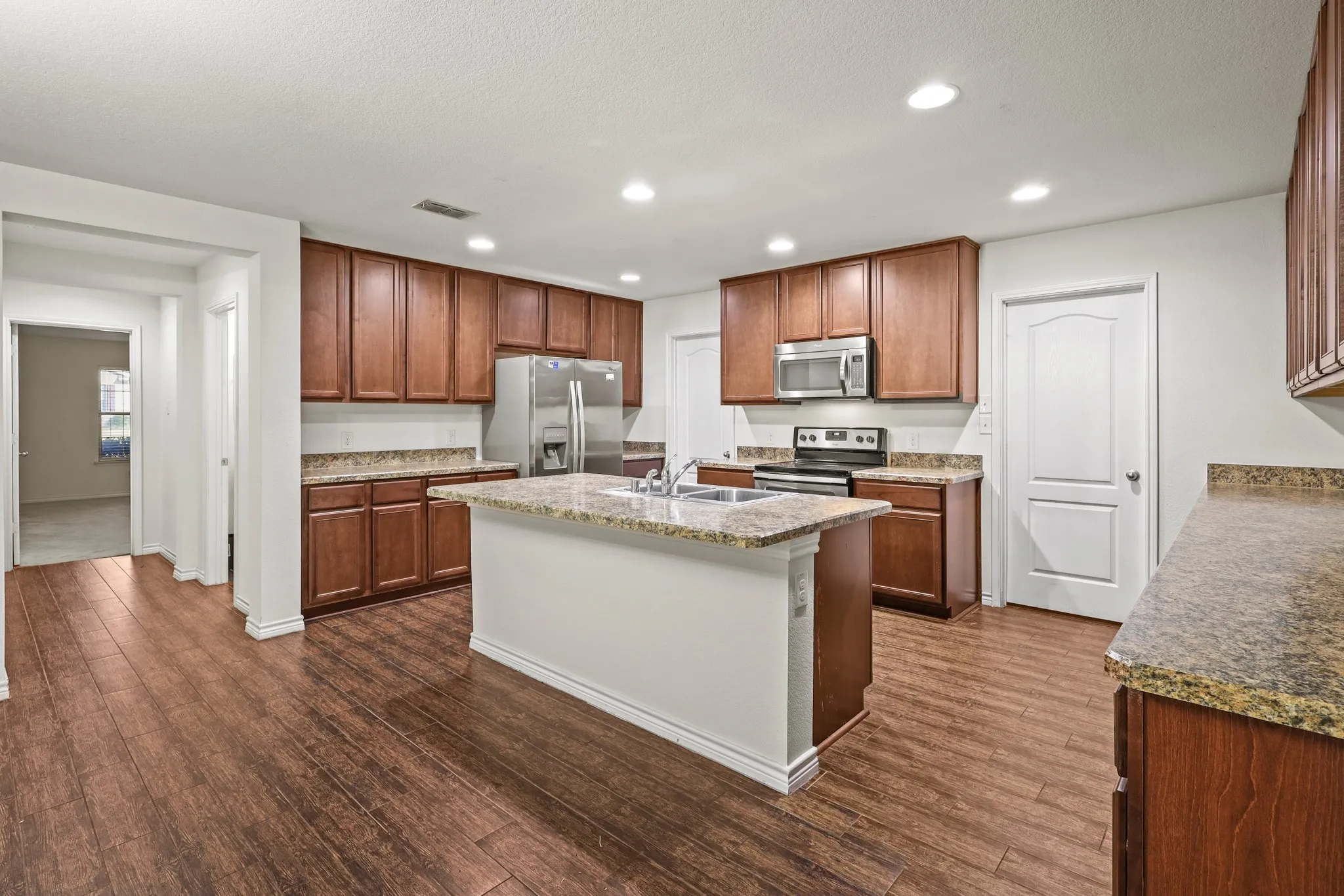 Kitchen featuring dark hardwood / wood-style flooring, stainless steel appliances, and sink